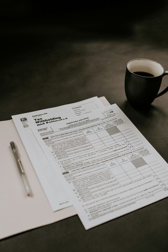 black ceramic mug beside white printer paper illustrating the tax return form