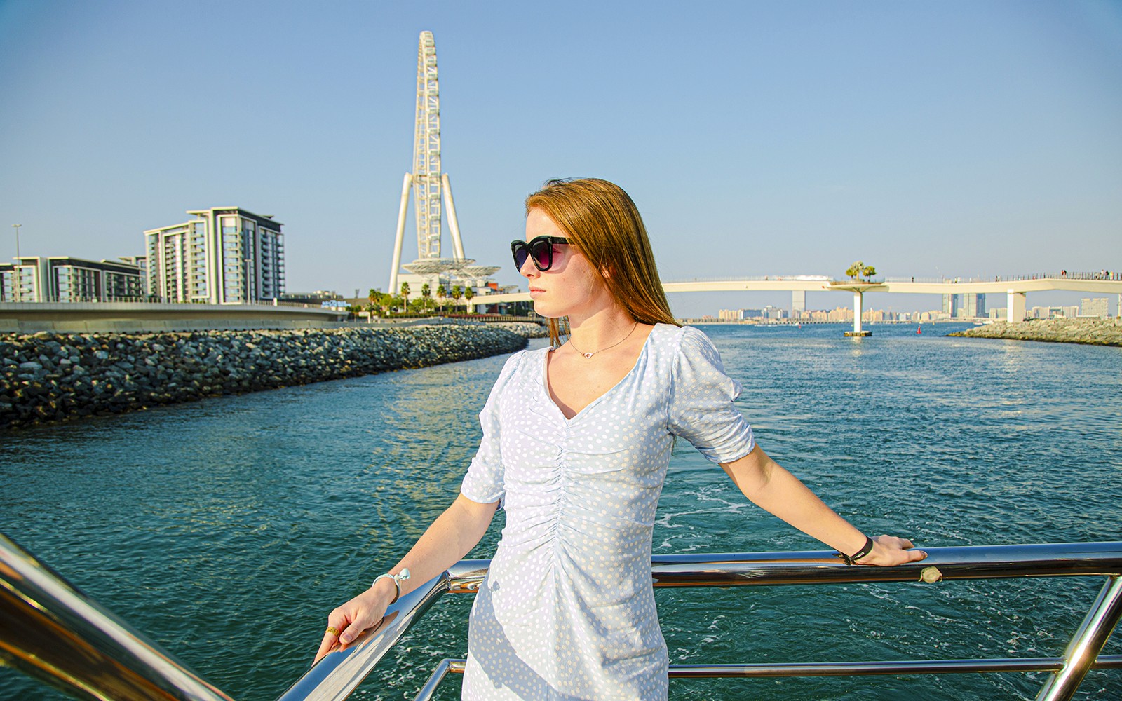 여성이 두바이 마리나에서 아인 두바이를 배경으로 한 관광 두우 크루즈를 즐기고 있습니다.