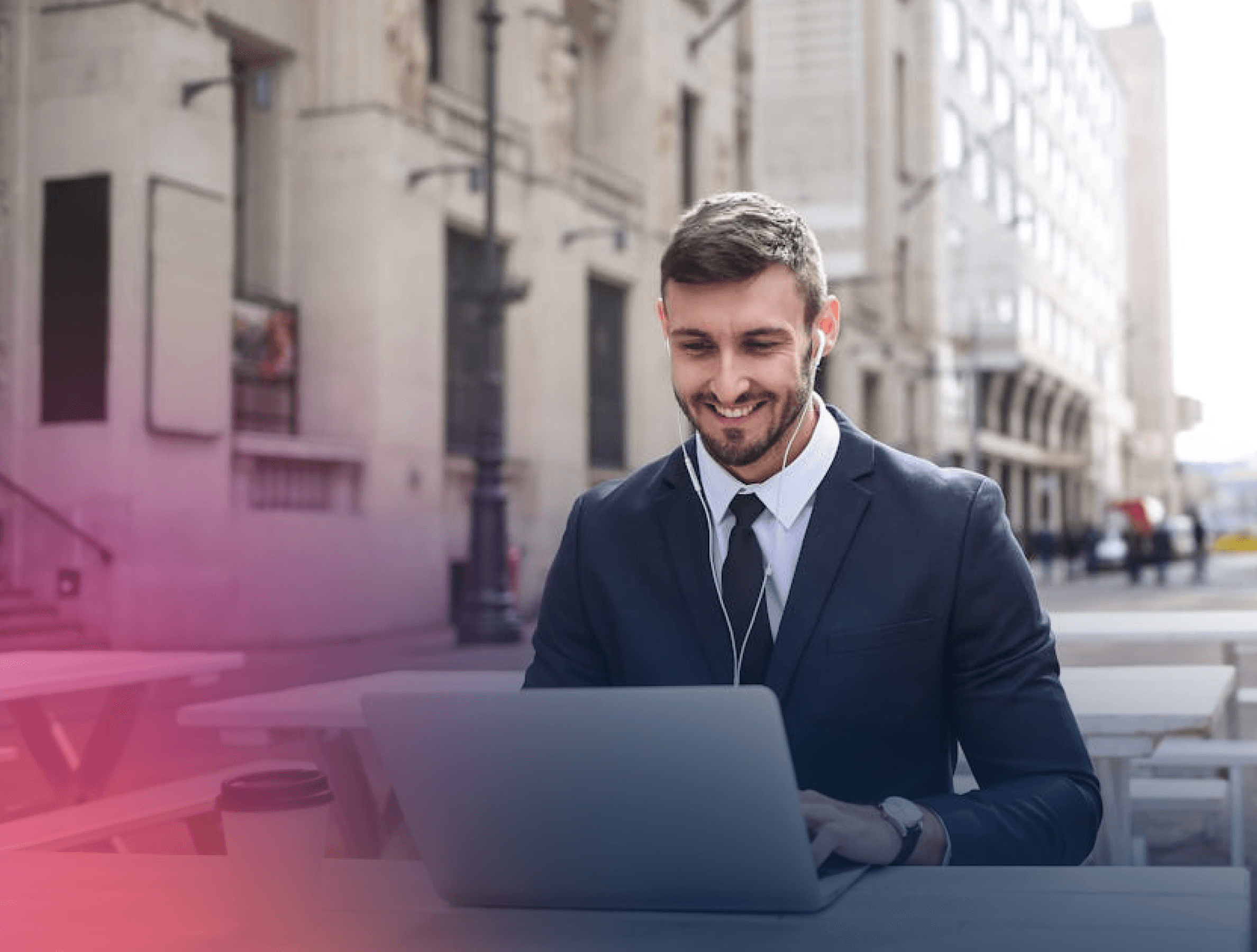 Man in suit sat outside with laptop
