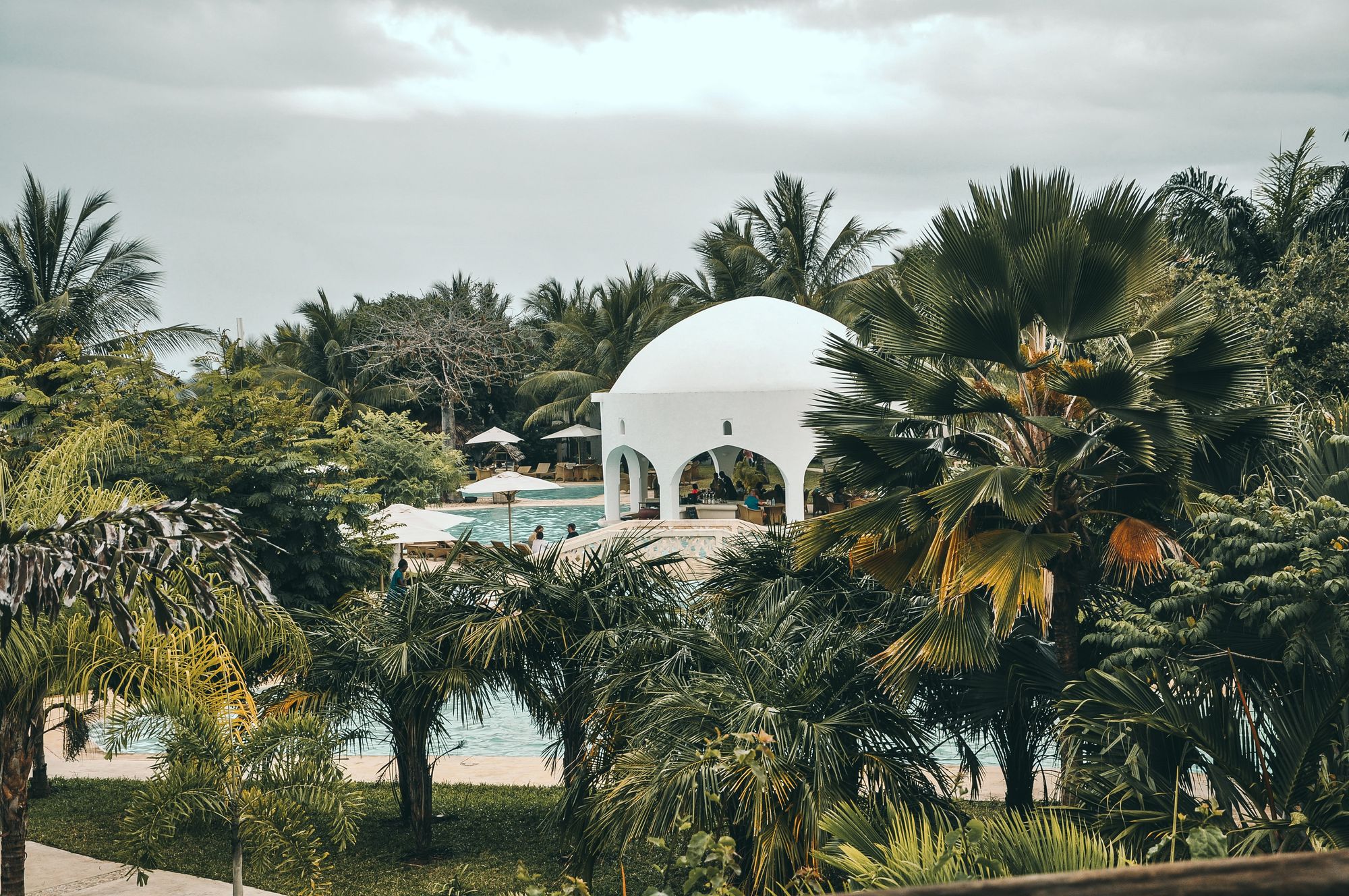 Palm trees surrounding a swimming pool and domed bar in Mombasa