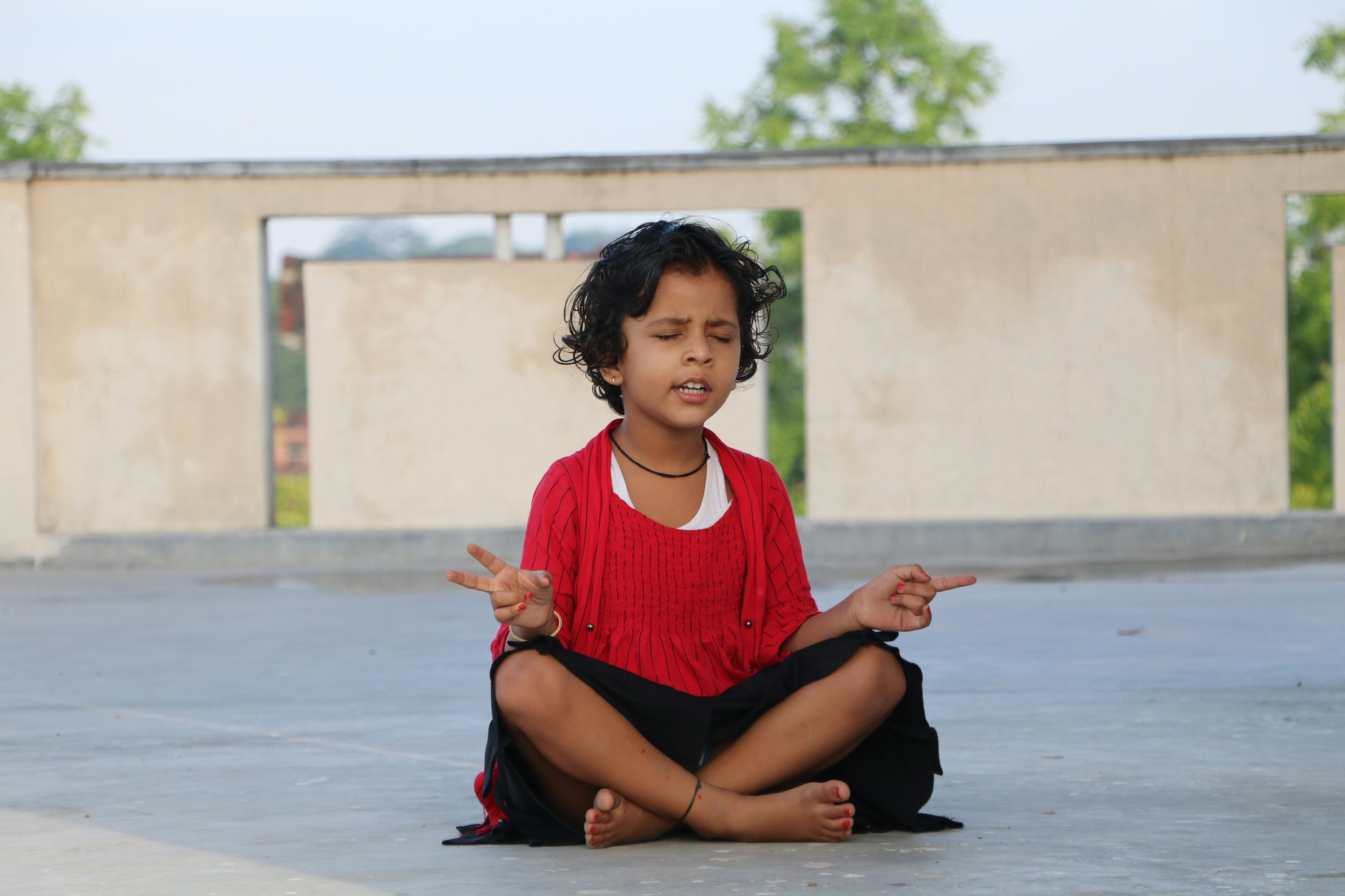 woman in red scoop neck shirt and black skirt sitting on floor