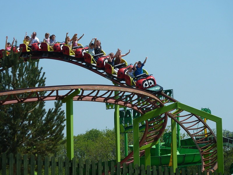 Red and green roller coaster track with train in motion