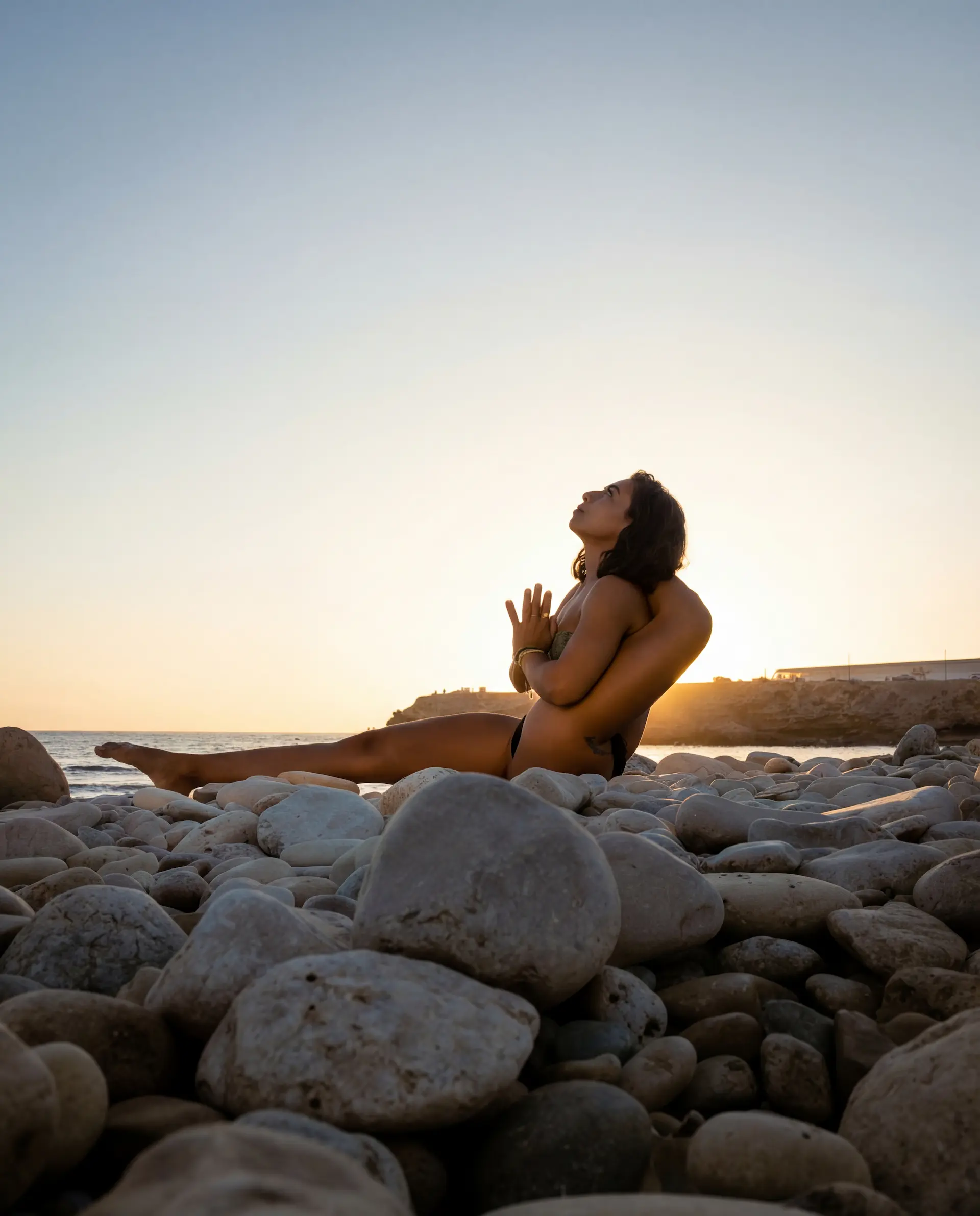 Yoga teacher training student practicing sound healing meditation with a Tibetan singing bowl in an open-air shala in Bali.