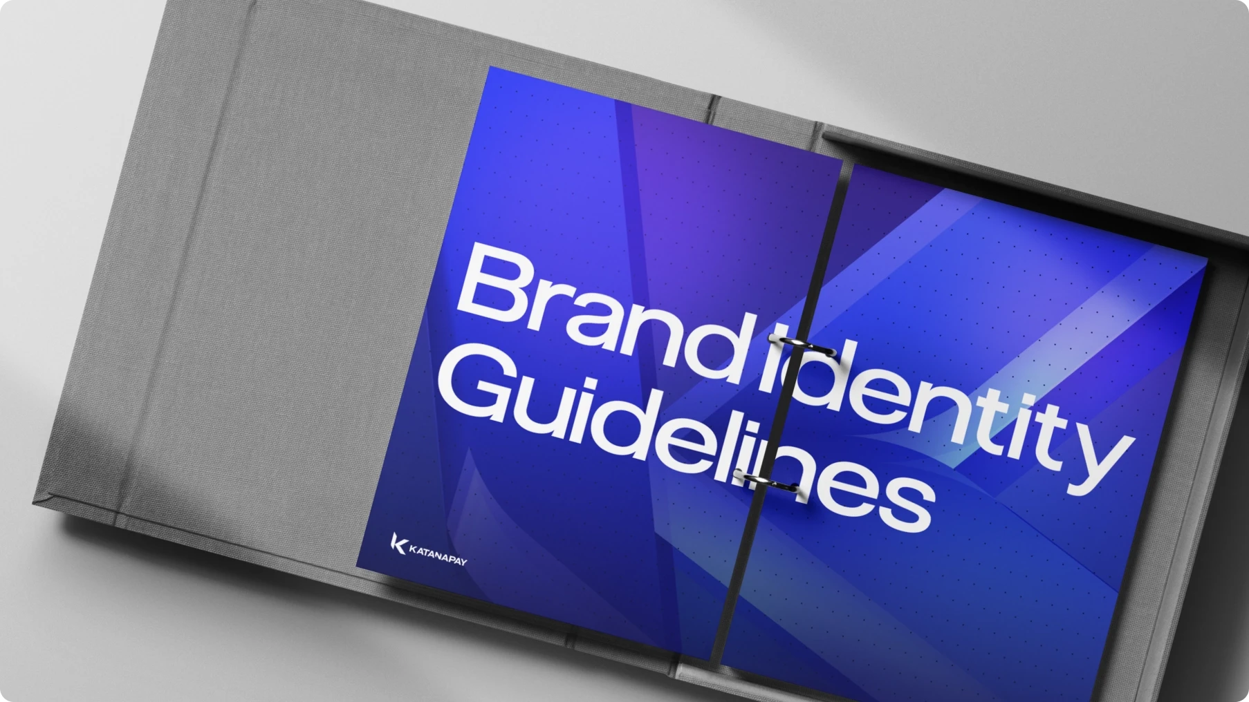 Angled view of a gray presentation case featuring a vivid blue geometric cover titled “Brand Identity Guidelines,” conveying a polished, modern tone.