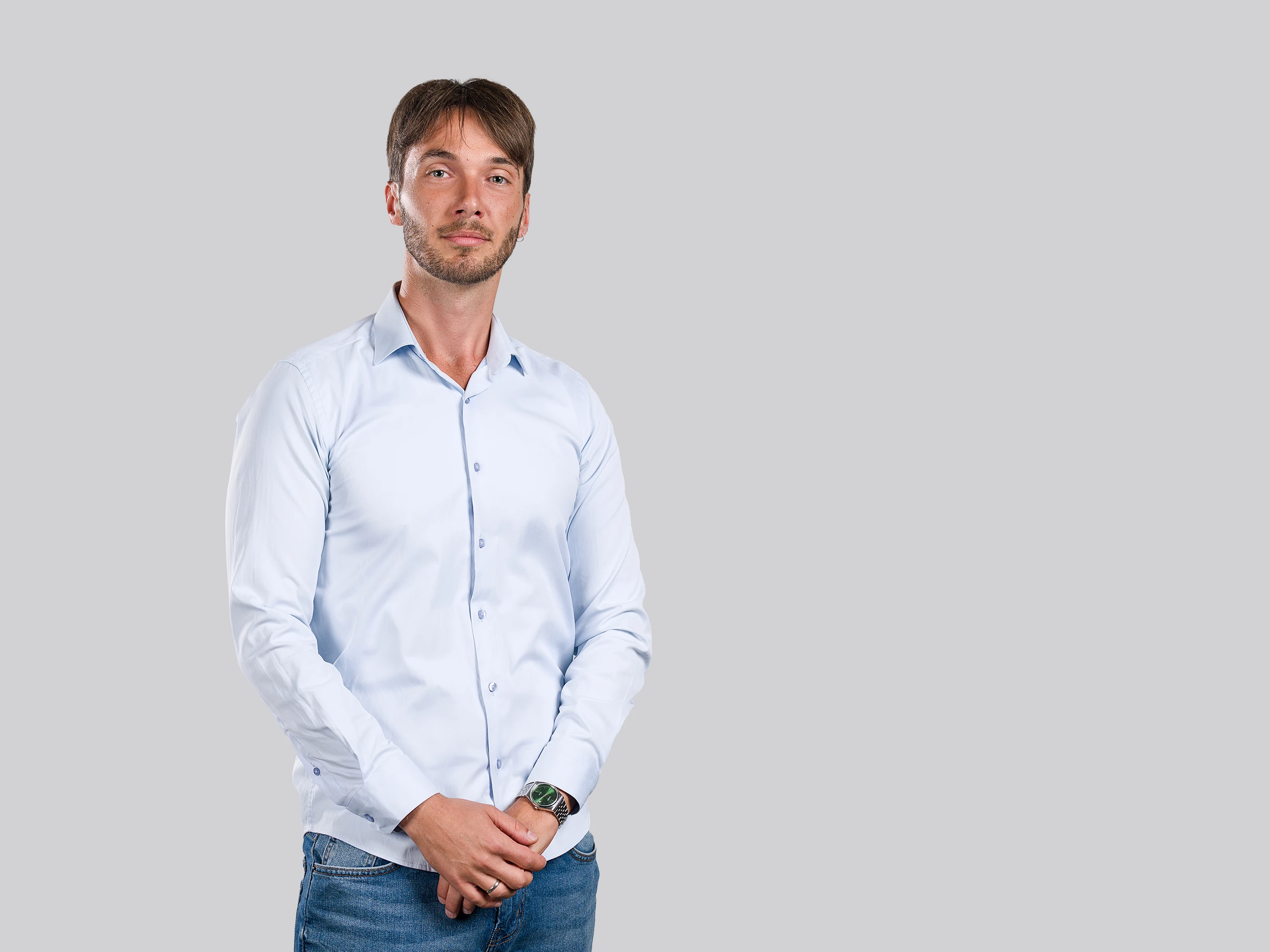 Corporate portrait of a professional man standing confidently in a studio setting.