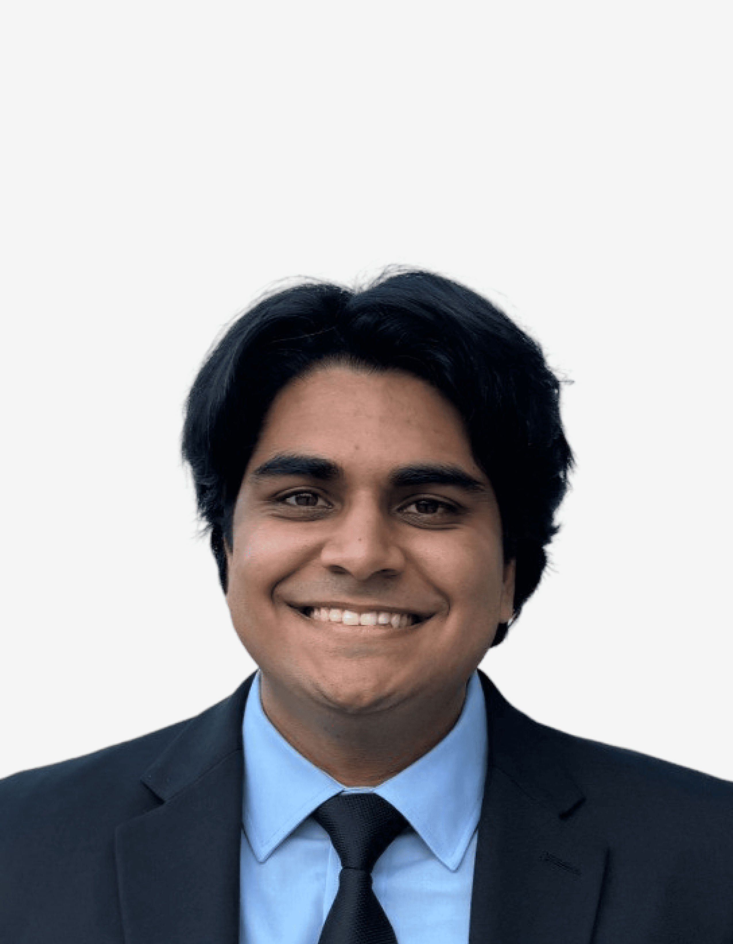 A smiling individual with dark, wavy hair wearing a black suit against a plain background.