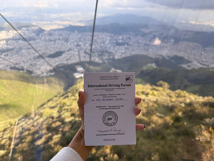 A hand holding an International Driving Permit from the cable car above Quito, Ecuador.