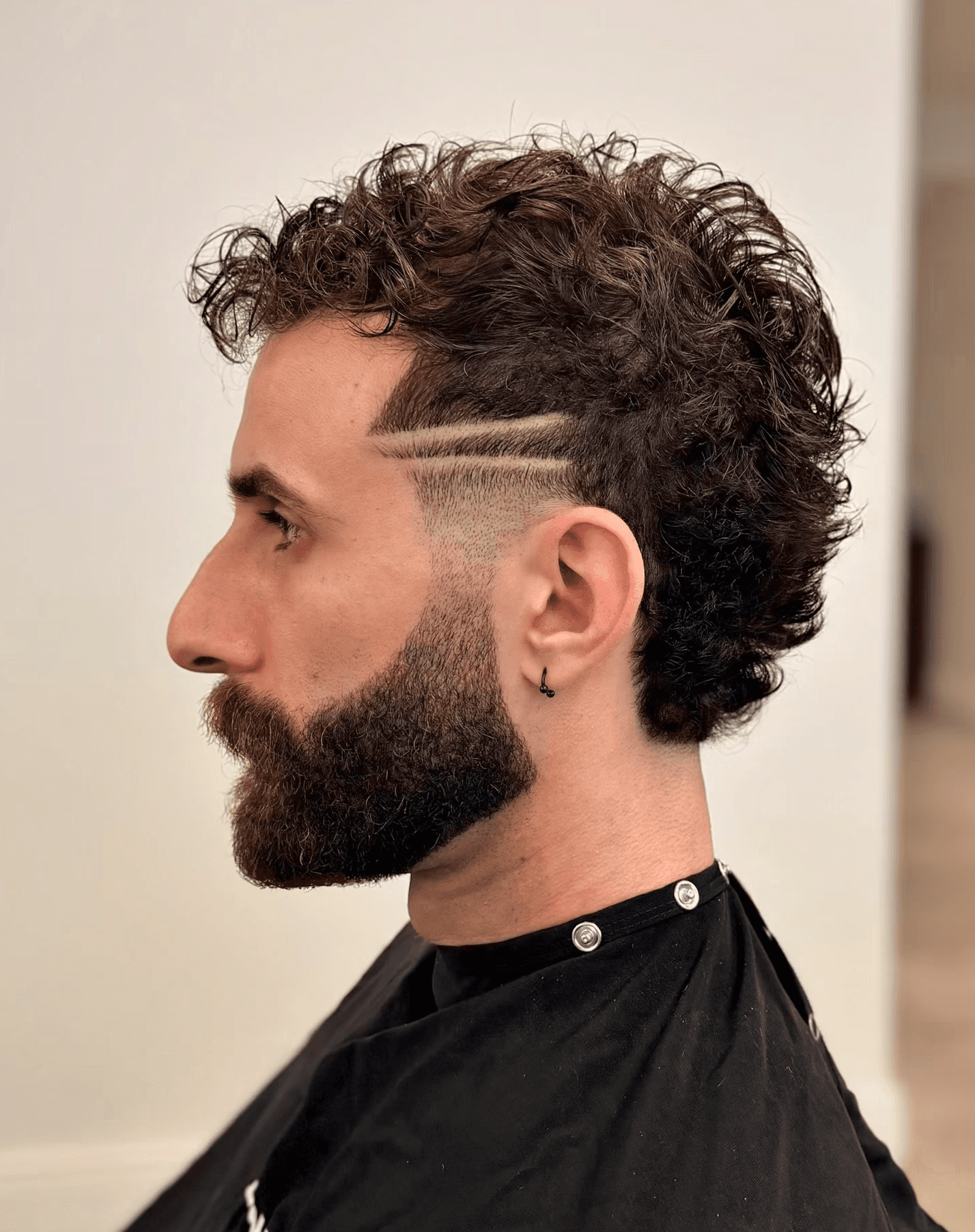 Modern mullet on curly hair with part design and beard grooming, done by Courtney Palmore. Beverly Hills Luxury Barber.  Working out of Bomane Salon.  Hairstylist