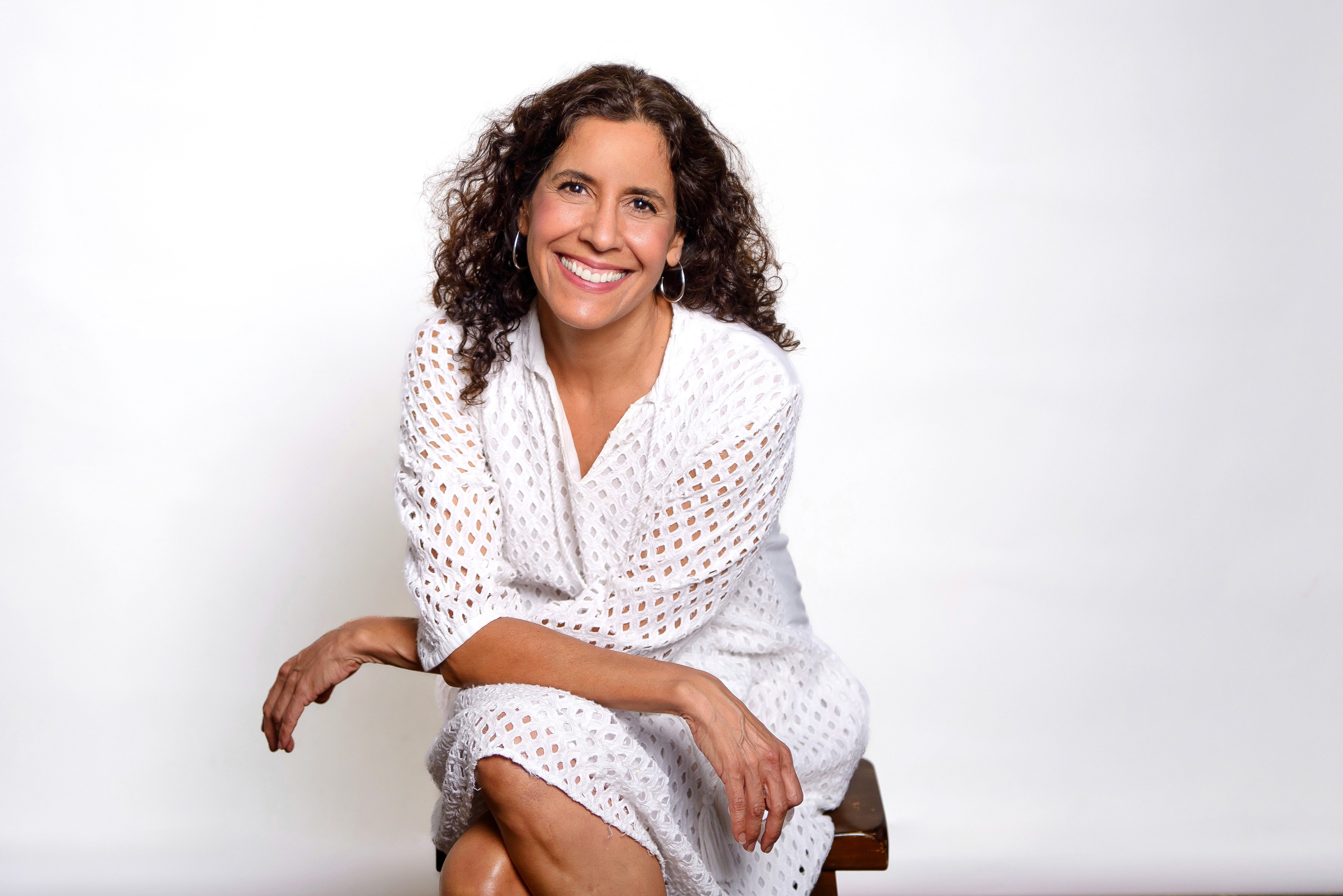 founder uptown atx studio, female business ina white dress against a white studio backdrop