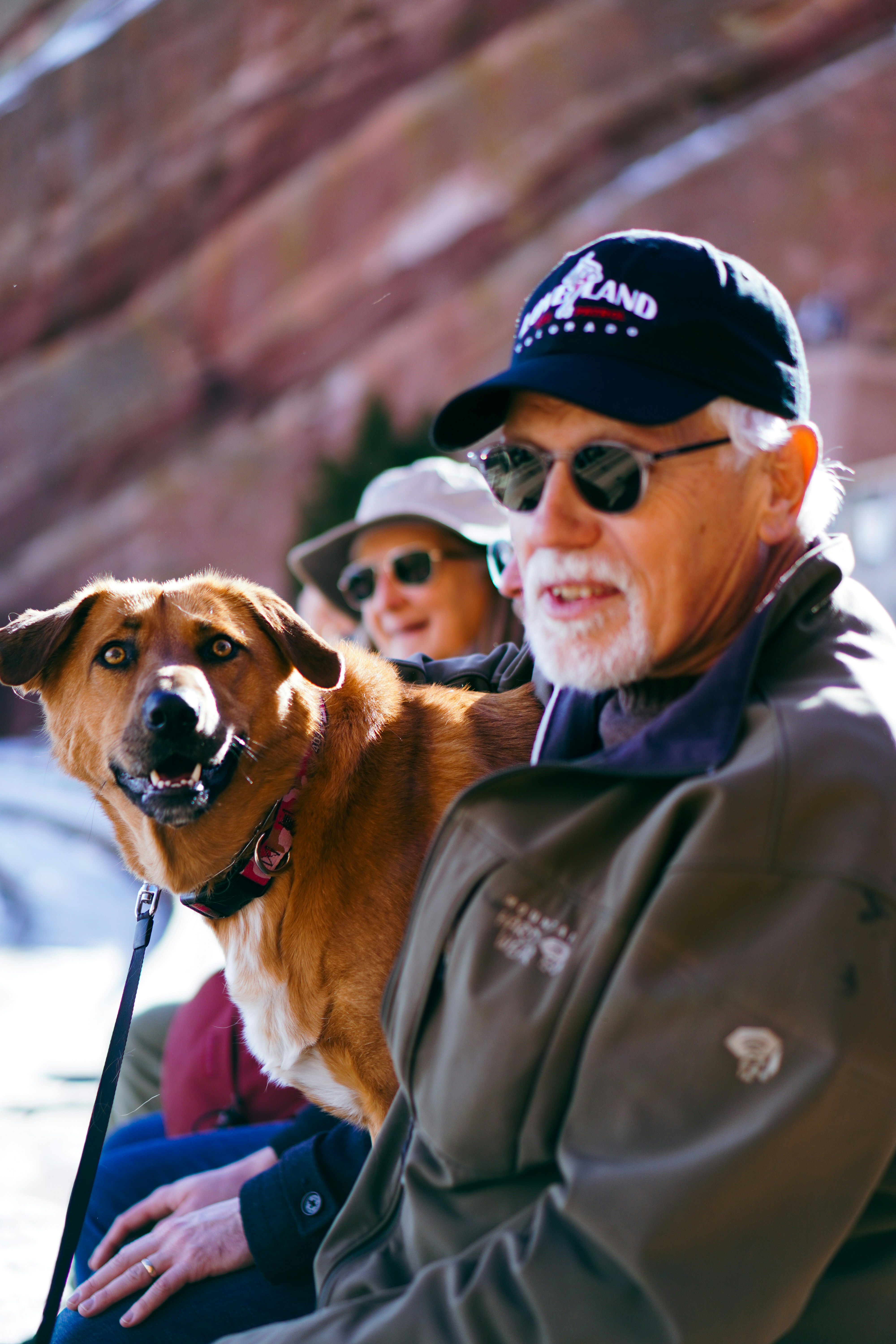 a man and a woman sitting next to a dog