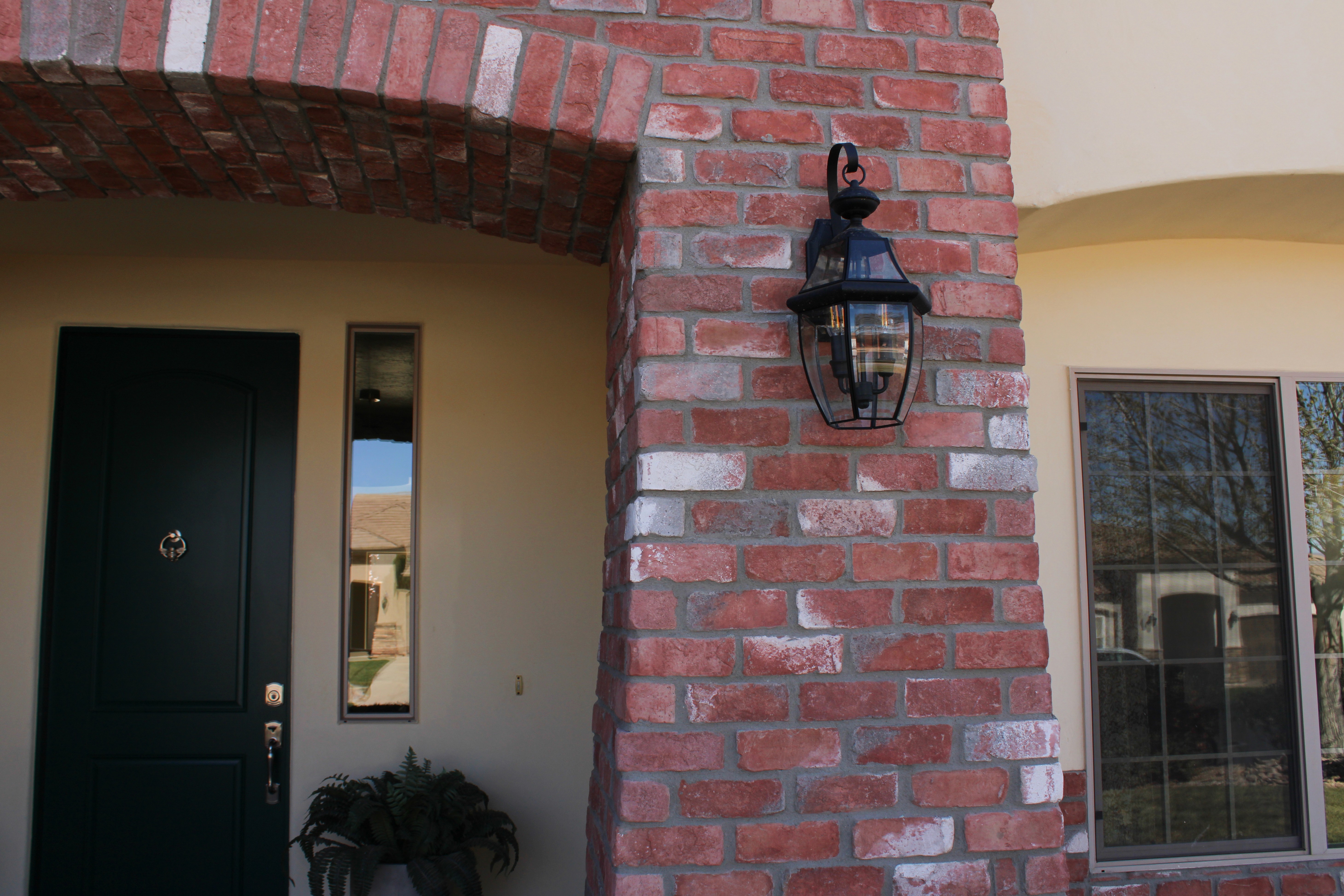 Close-up of stone exterior wall with modern wall sconce on a Washington, Utah custom home