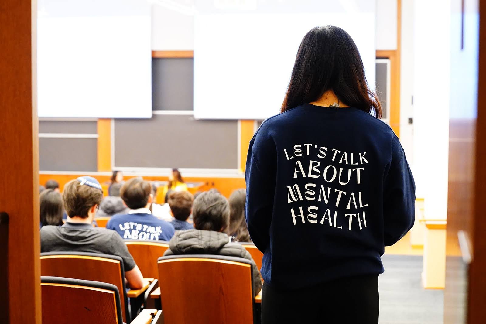 An image of the back of a student's hoodie that says "Let's talk about mental health"
