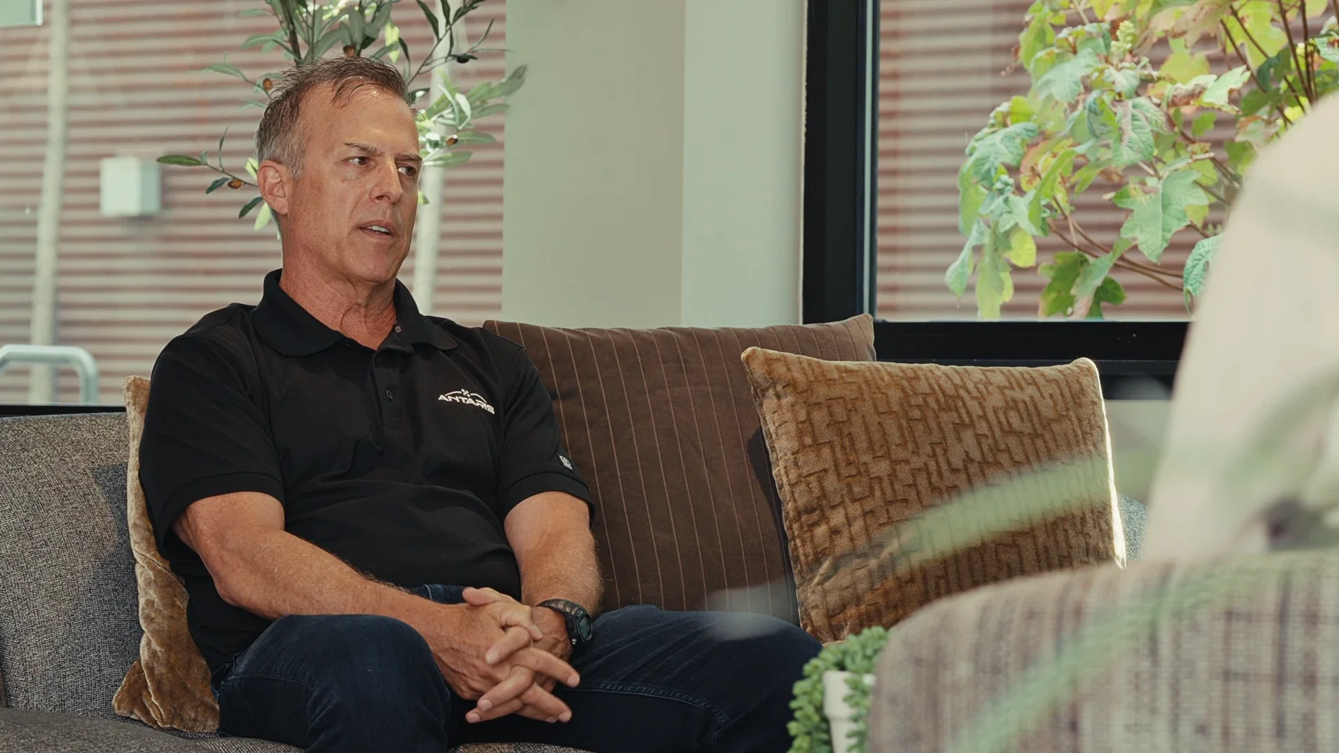 A man seated on a sofa during an interview