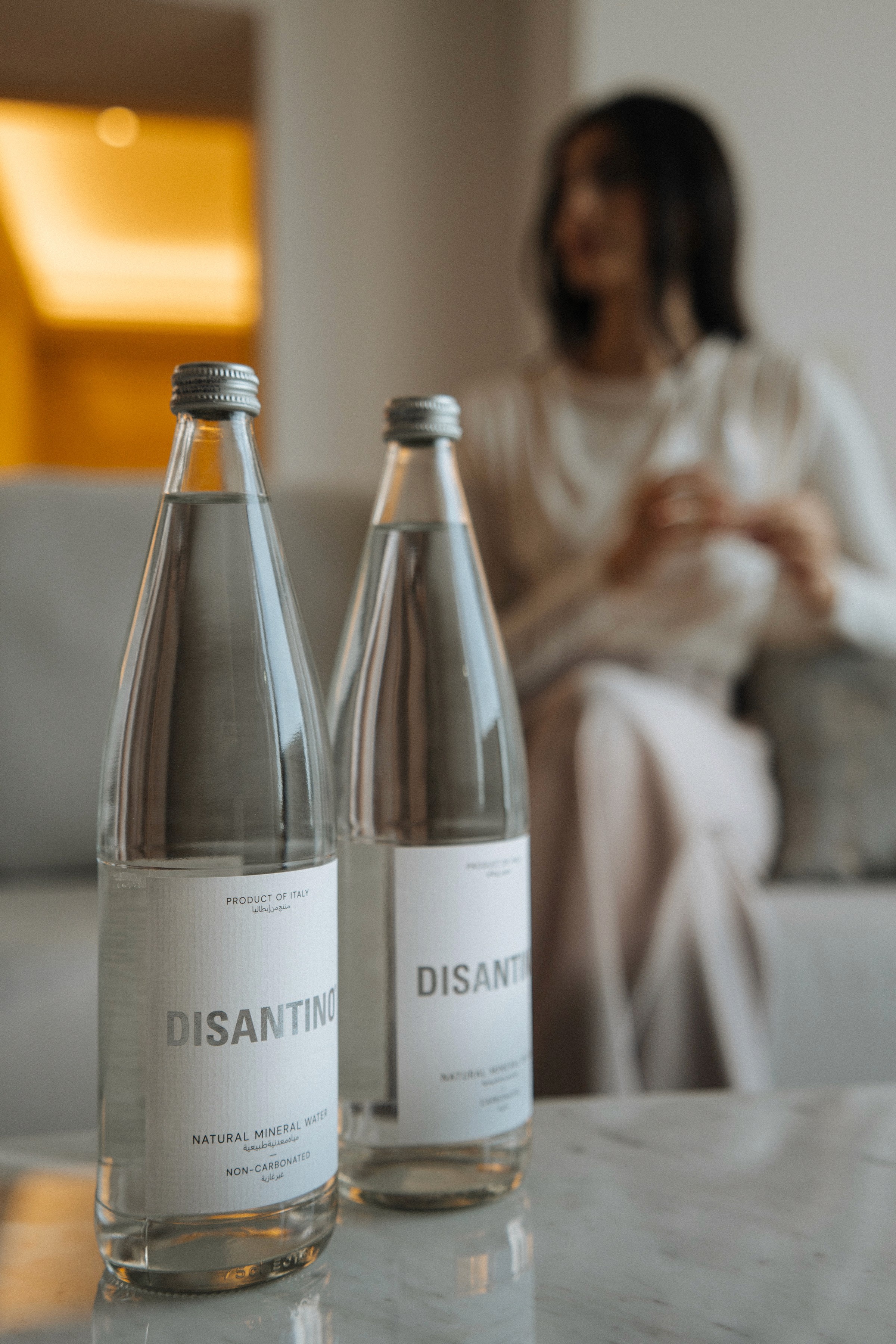 Two bottles of DISANTINO mineral water placed upon a coffee table.