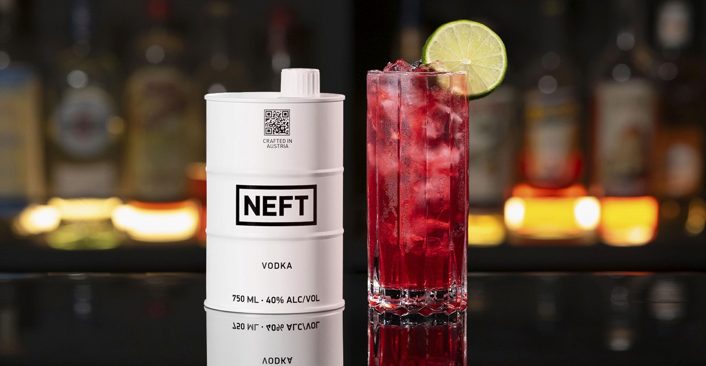 A NEFT Barrel and a glass of Sea Breeze on a bar counter.