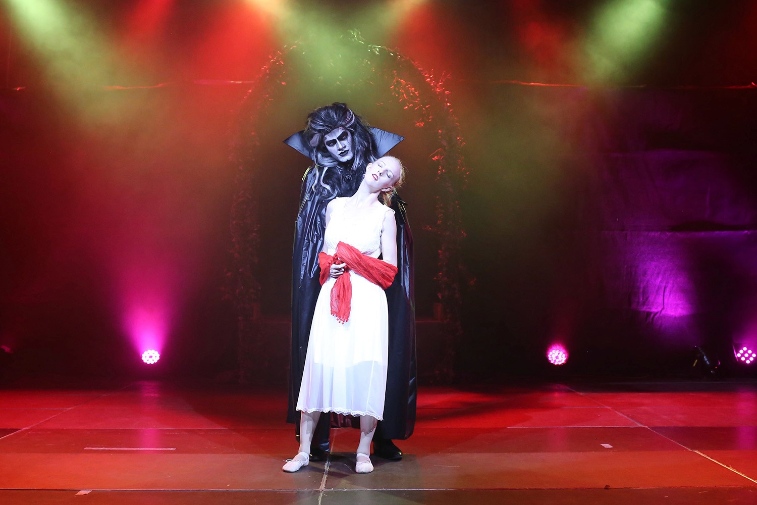 Szenische Tanzperformance mit dramatischer Beleuchtung, bei der zwei Tänzer eine individuell gestaltete Showeinlage darstellen.