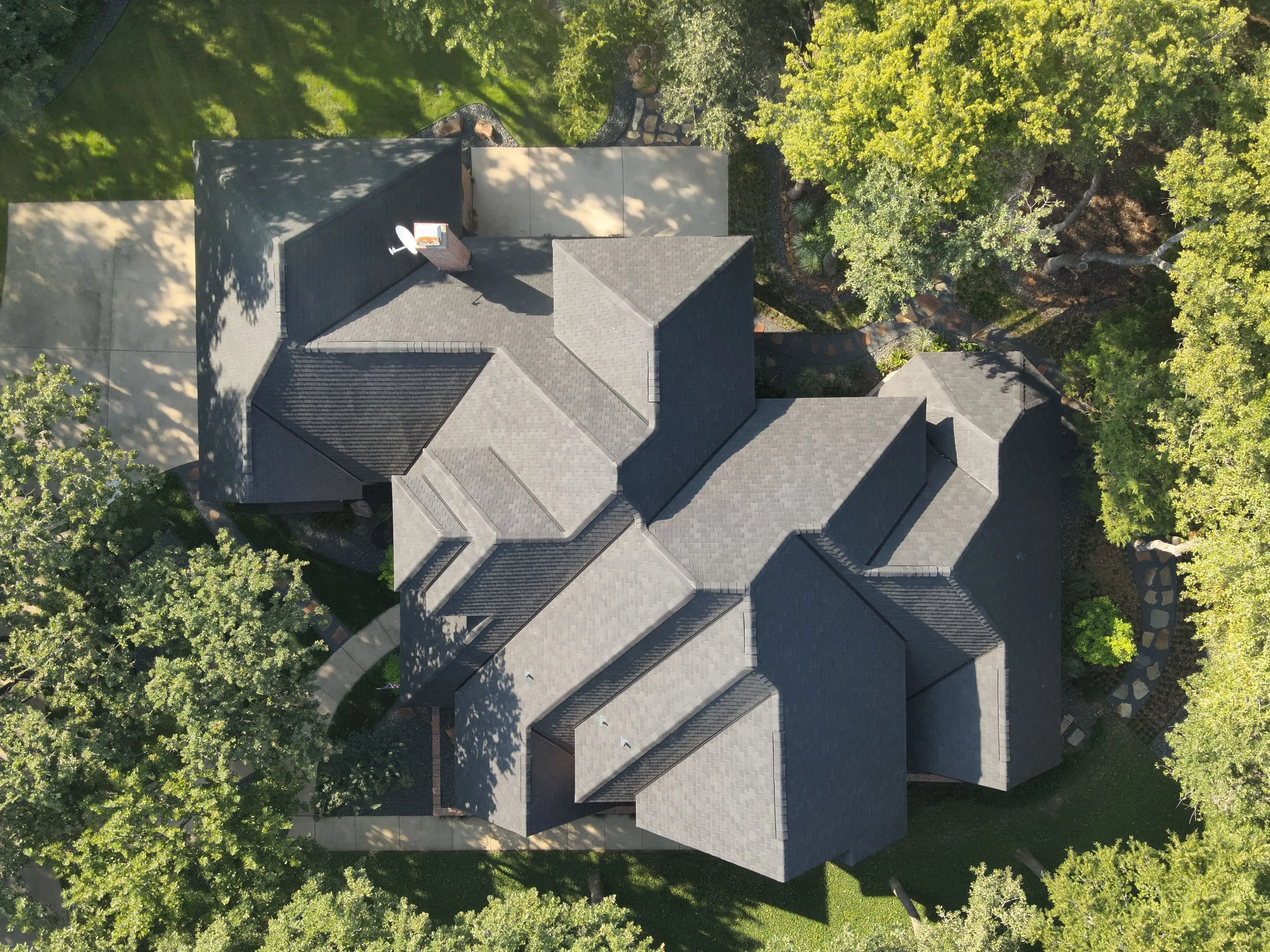 Drone photography of F-Wave high-performance synthetic shingles on residential home in Corinth TX surrounded by mature trees