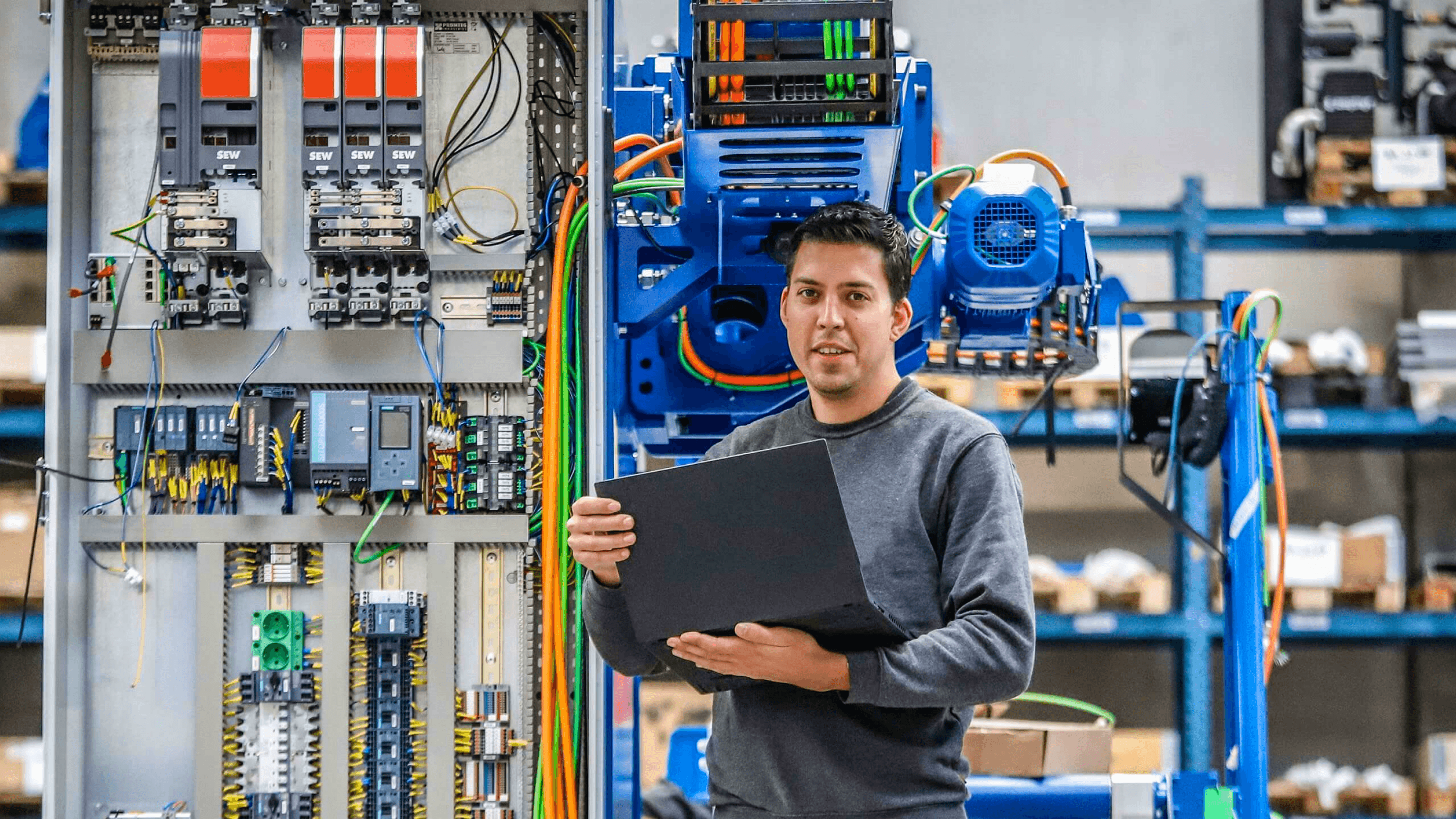 technician holding a laptop in front of industrial electrical switchgear in a workshop — Soda Studio case study