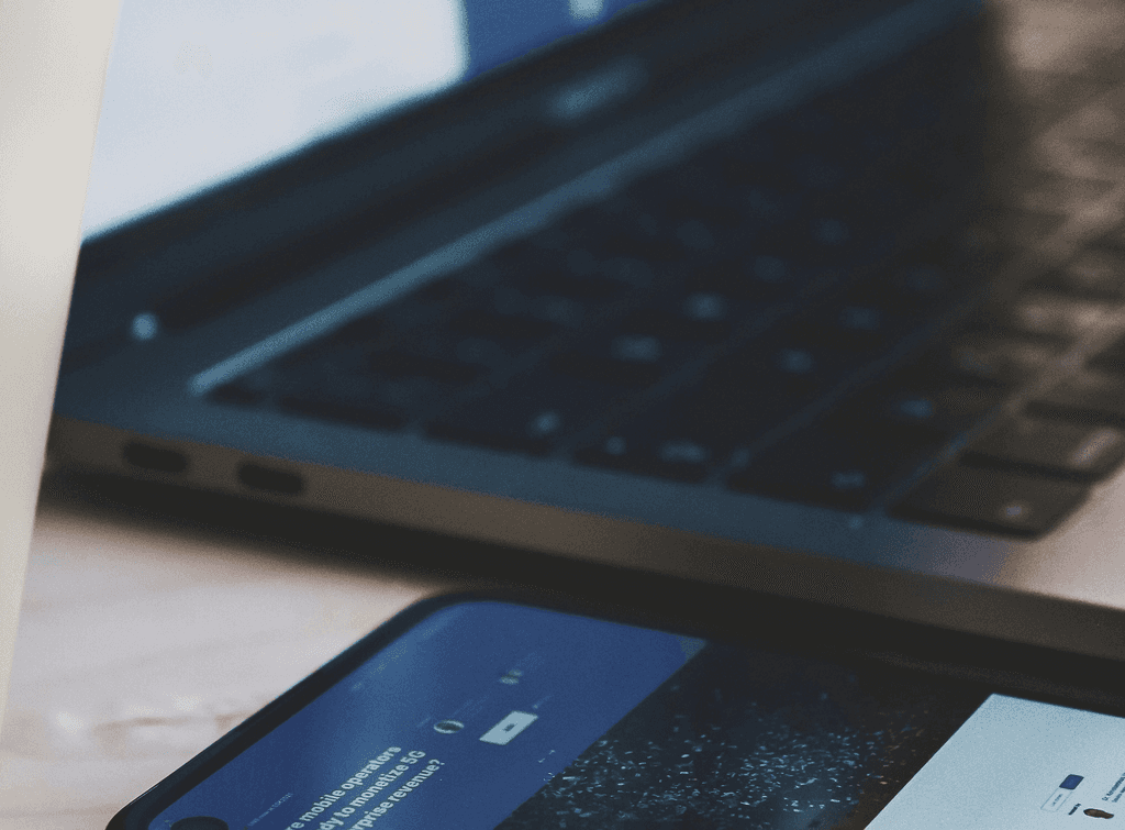 Ein Handy und ein laptop liegen auf dem Tisch