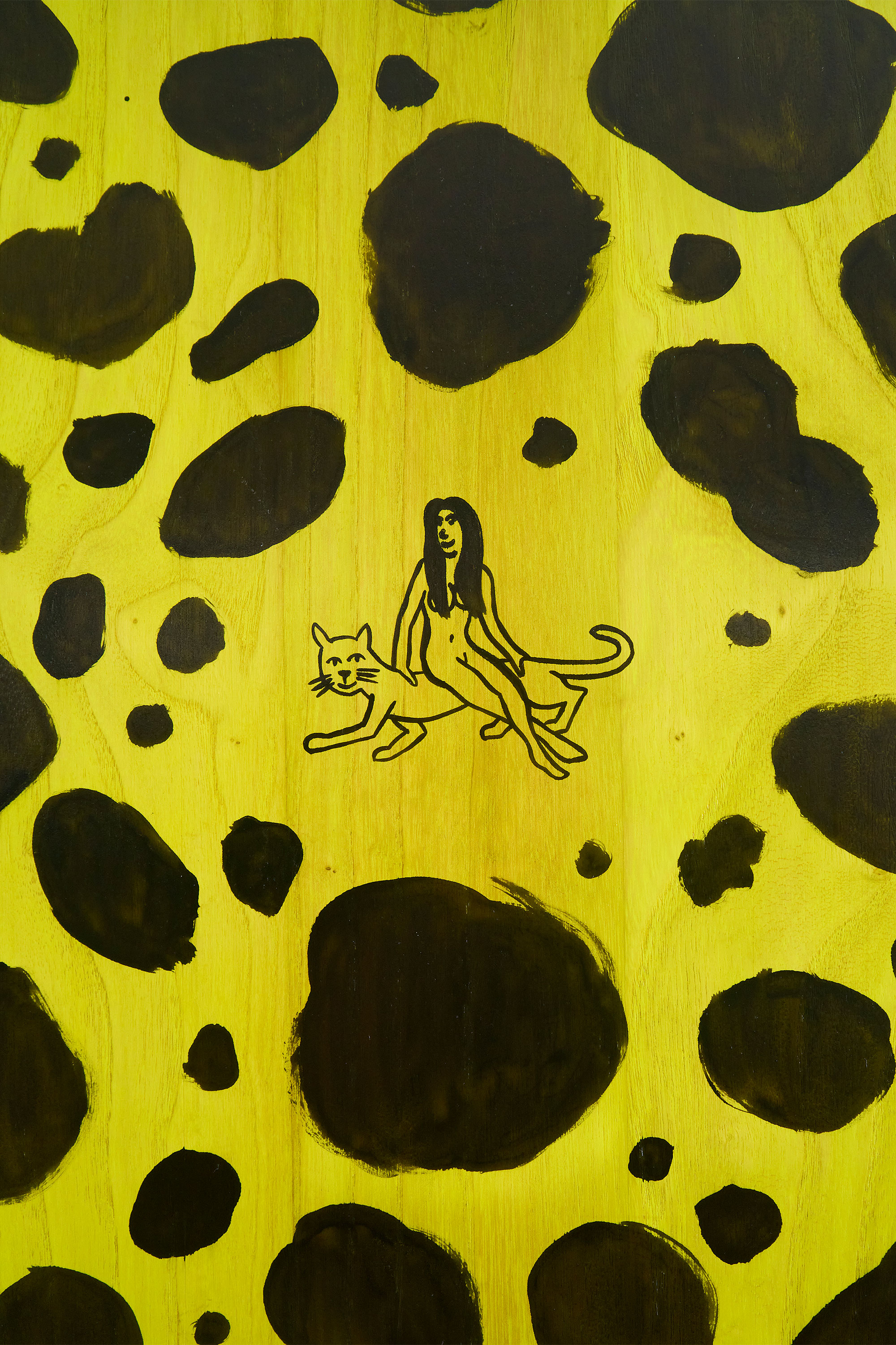 Woman sitting on big cat painted artwork close up