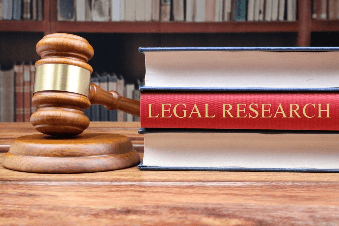 High school student researching law topics at a desk with legal books and a laptop