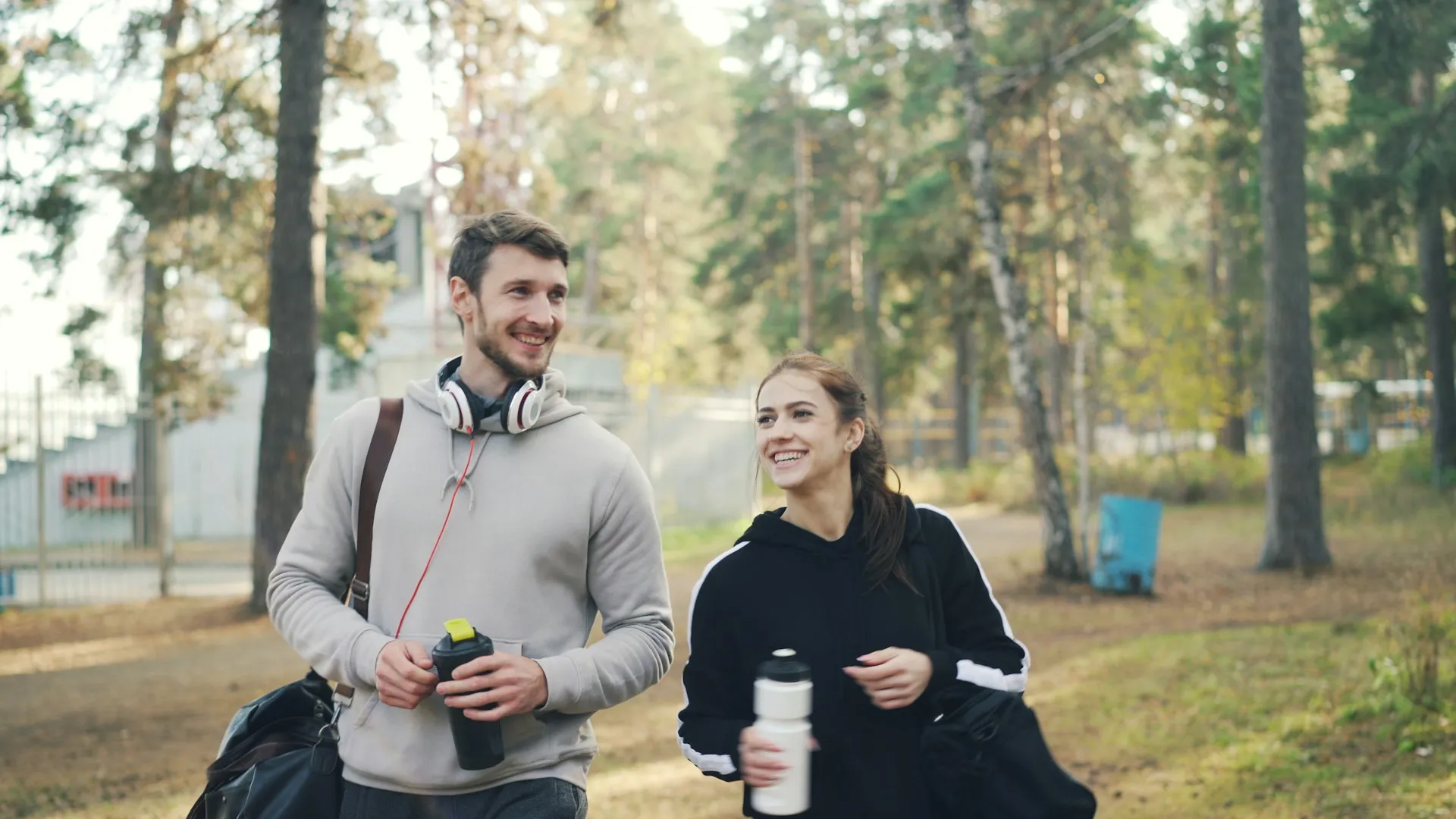 Man jogging outdoors in an urban residential area wearing a beanie and earphones