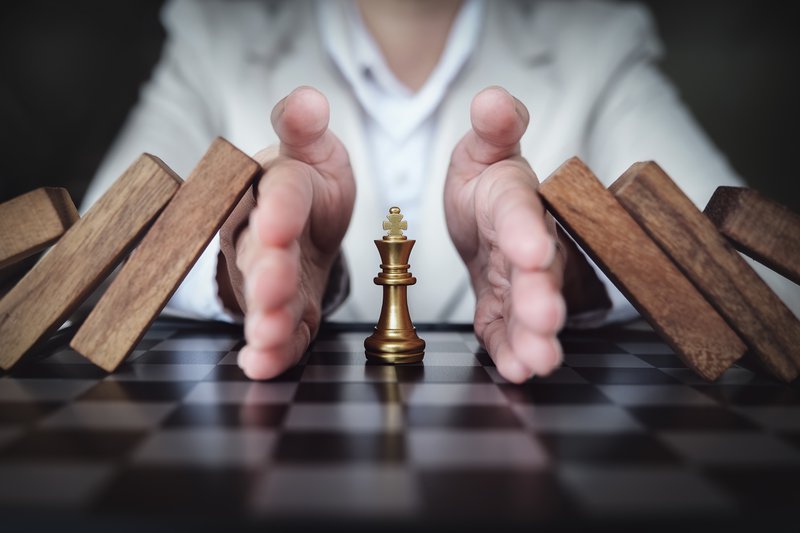 Preventing the risk of playing chess on a business board, business insurance concept.