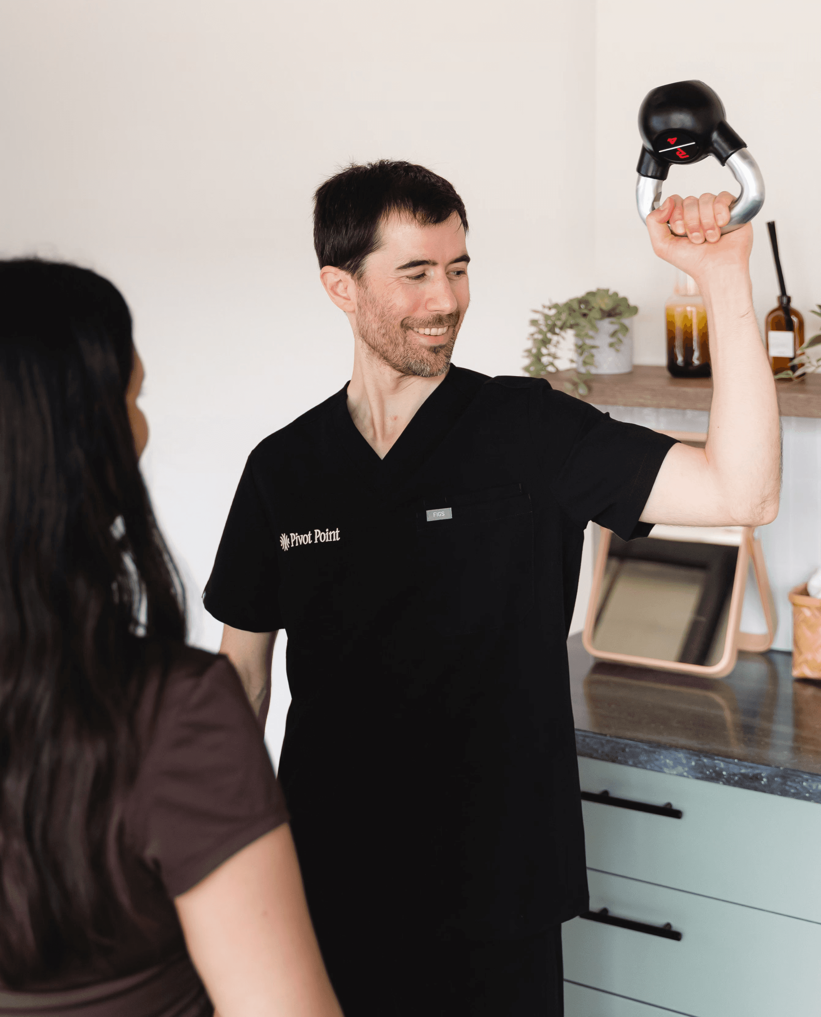 A physiotherapist demonstrating an exercise to a patient