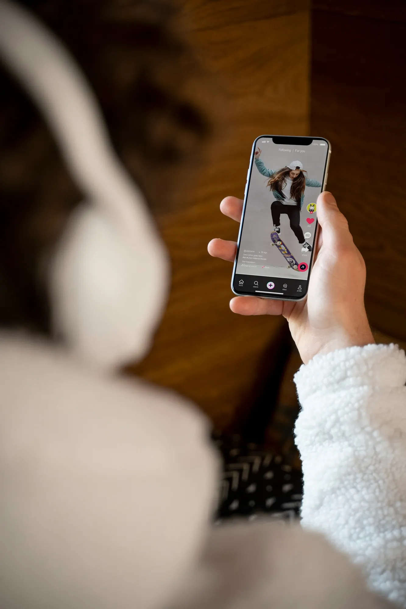 A user scrolling the TikTok 'For You' feed, where new AI creation tools are now integrated.