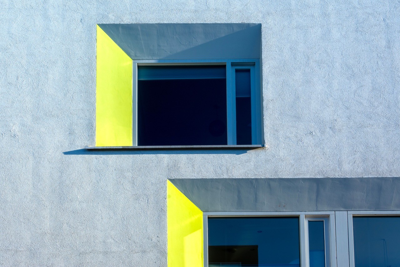 Moderne Fassade mit gelb gerahmten Fenstern