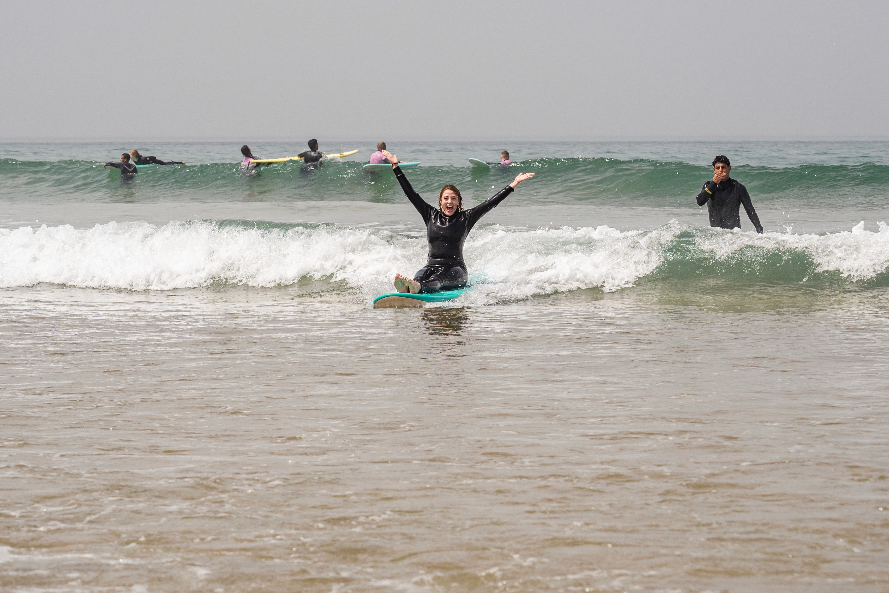 a group of people carrying surfboards on top of a beach
