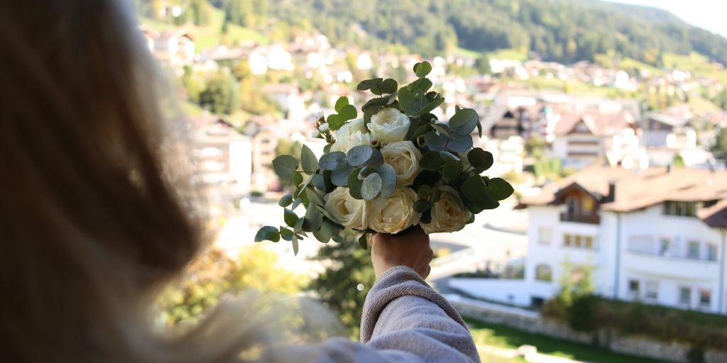 a woman holding a bouquet of flowers in her hand