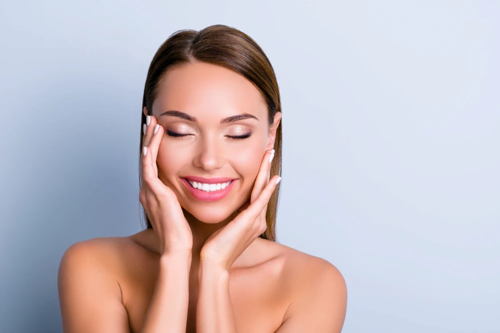 Woman smiling with glowing skin after PDO threads treatment.