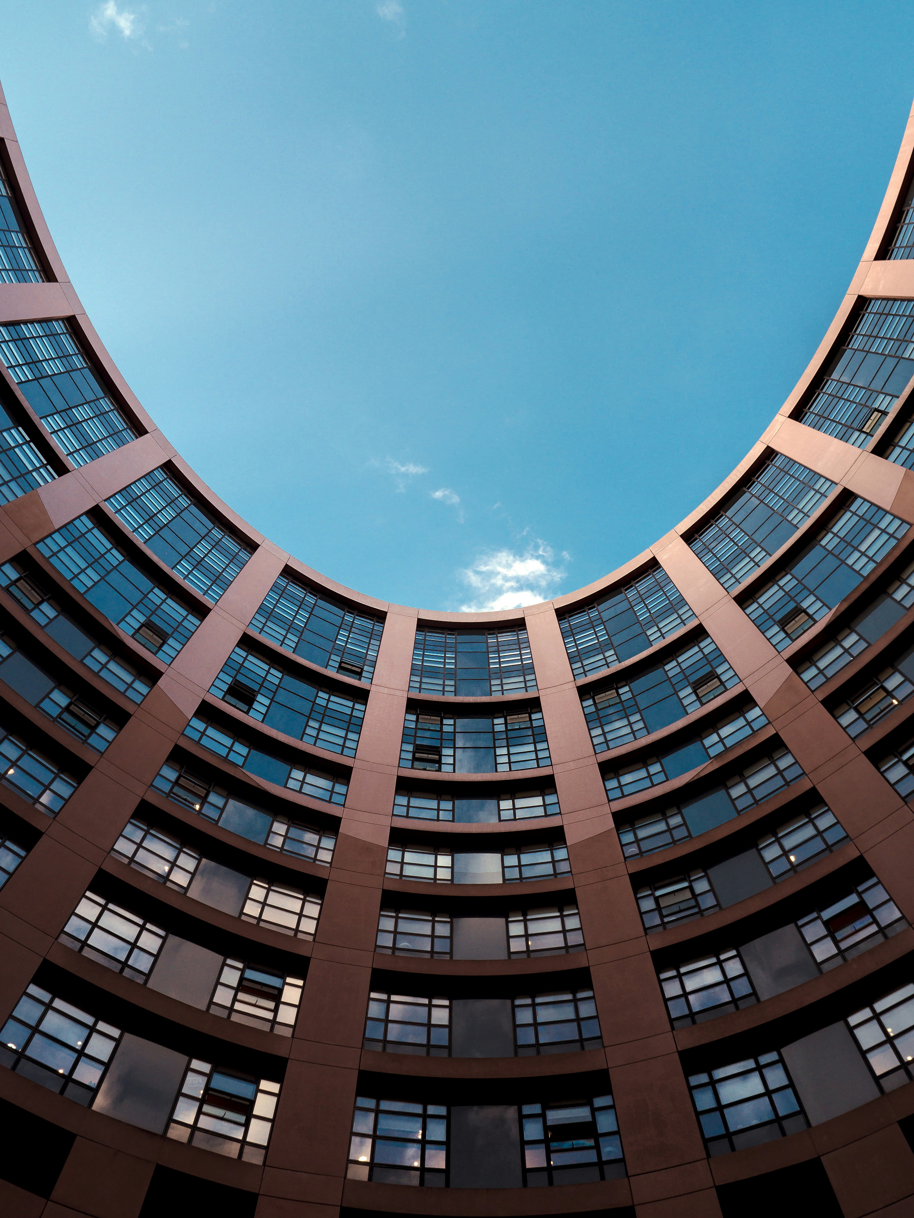 low-angle photography of gray building under blue sky at daytime