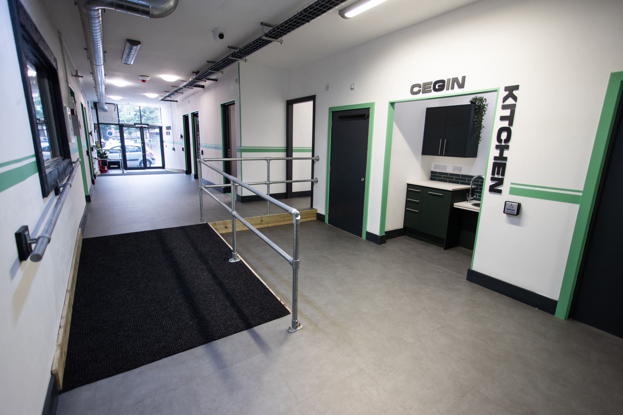 A room with green lighting and a ramp.