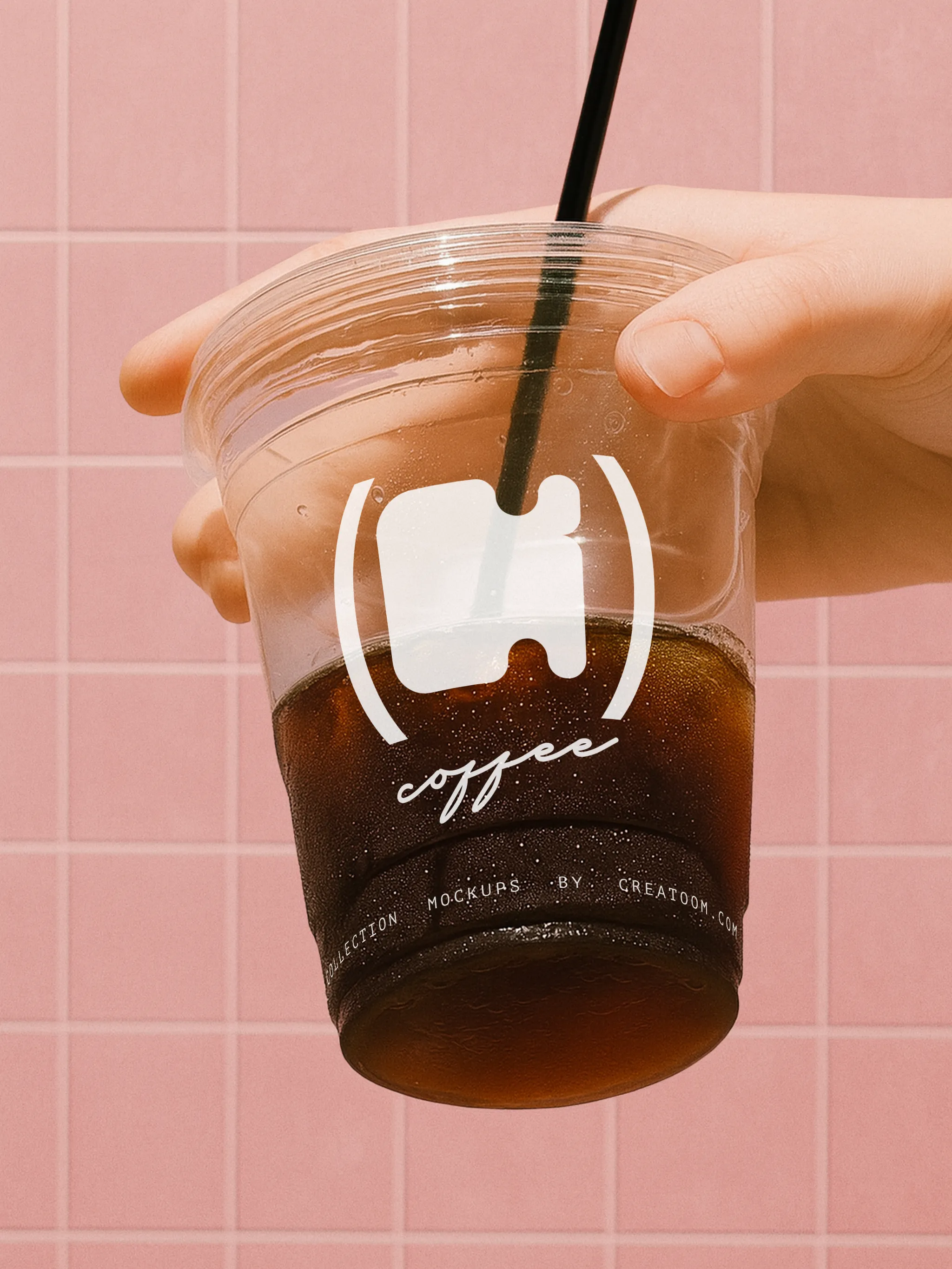 Branded iced coffee cup with white logo against pink tiles