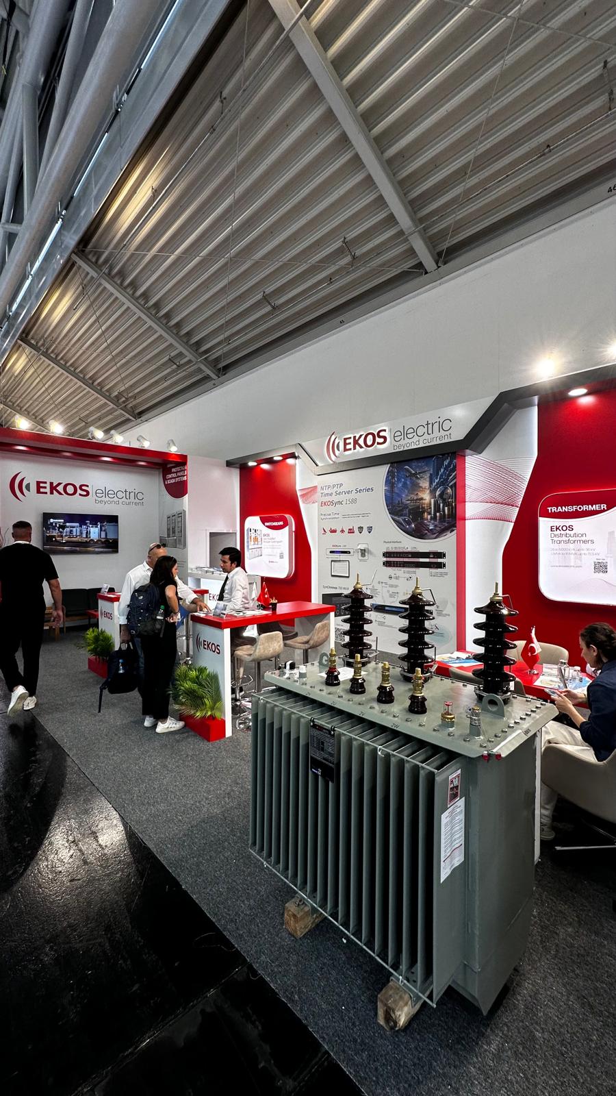 Heavy transformer display at the front of the EKOS Electric stand, communicating industrial capabilities and attracting visitor attention.