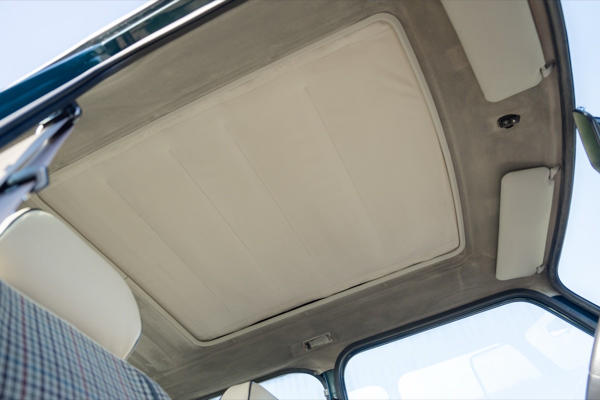 Close-up of a vehicle's interior ceiling, featuring a smooth, light-colored surface and structural details.