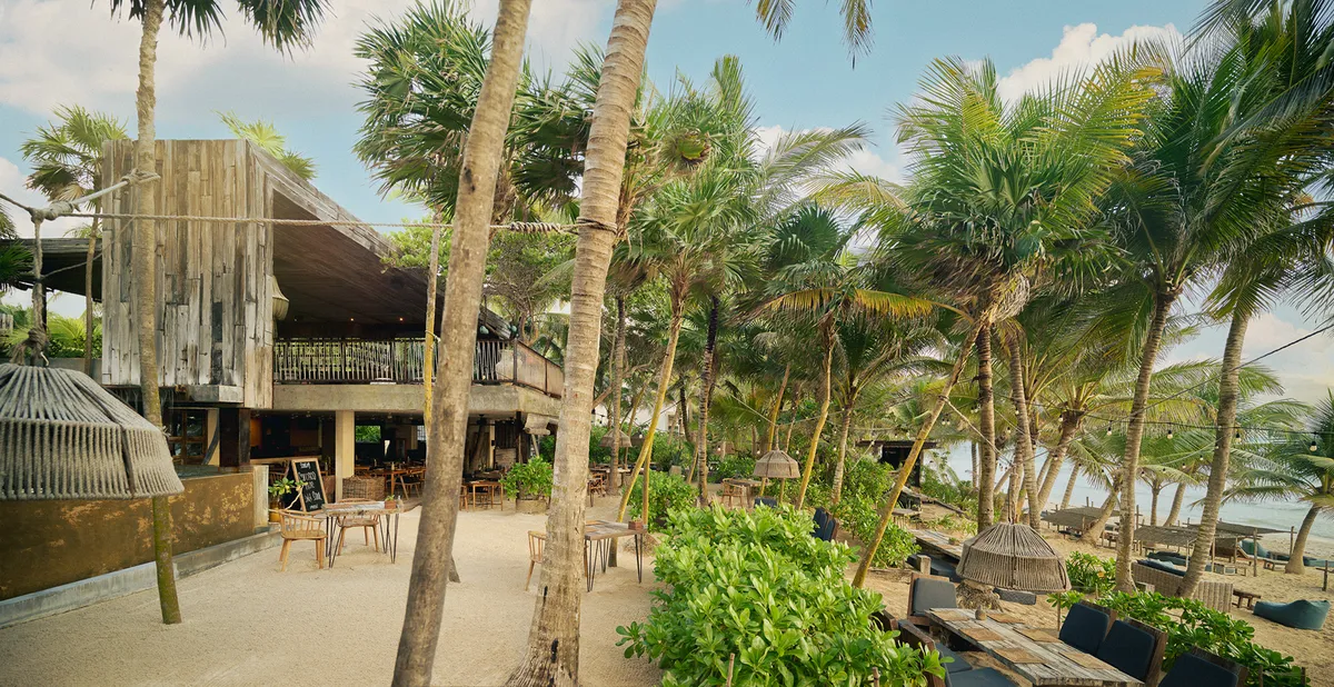Woman walking around private pool with lounge chairs and relaxation areas, surrounded by nature and jungle.