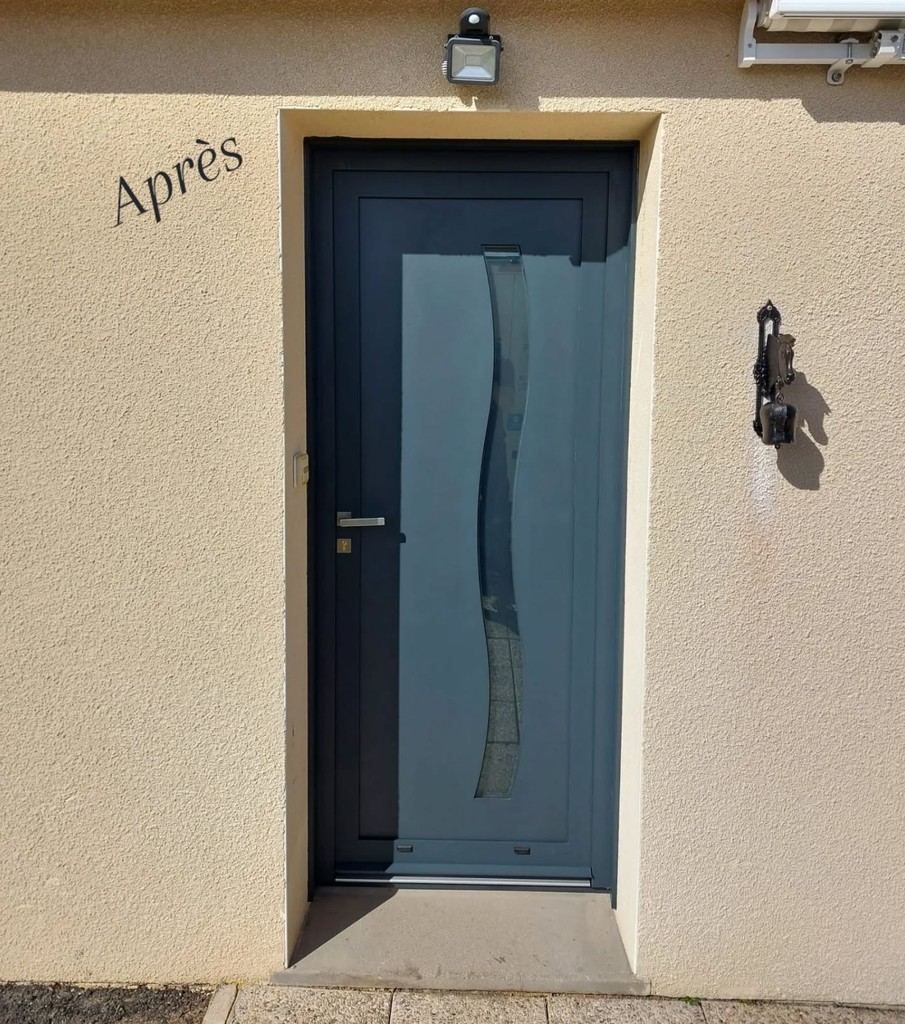 Porte d’entrée grise foncée “Après” avec vitrage incurvé vertical.