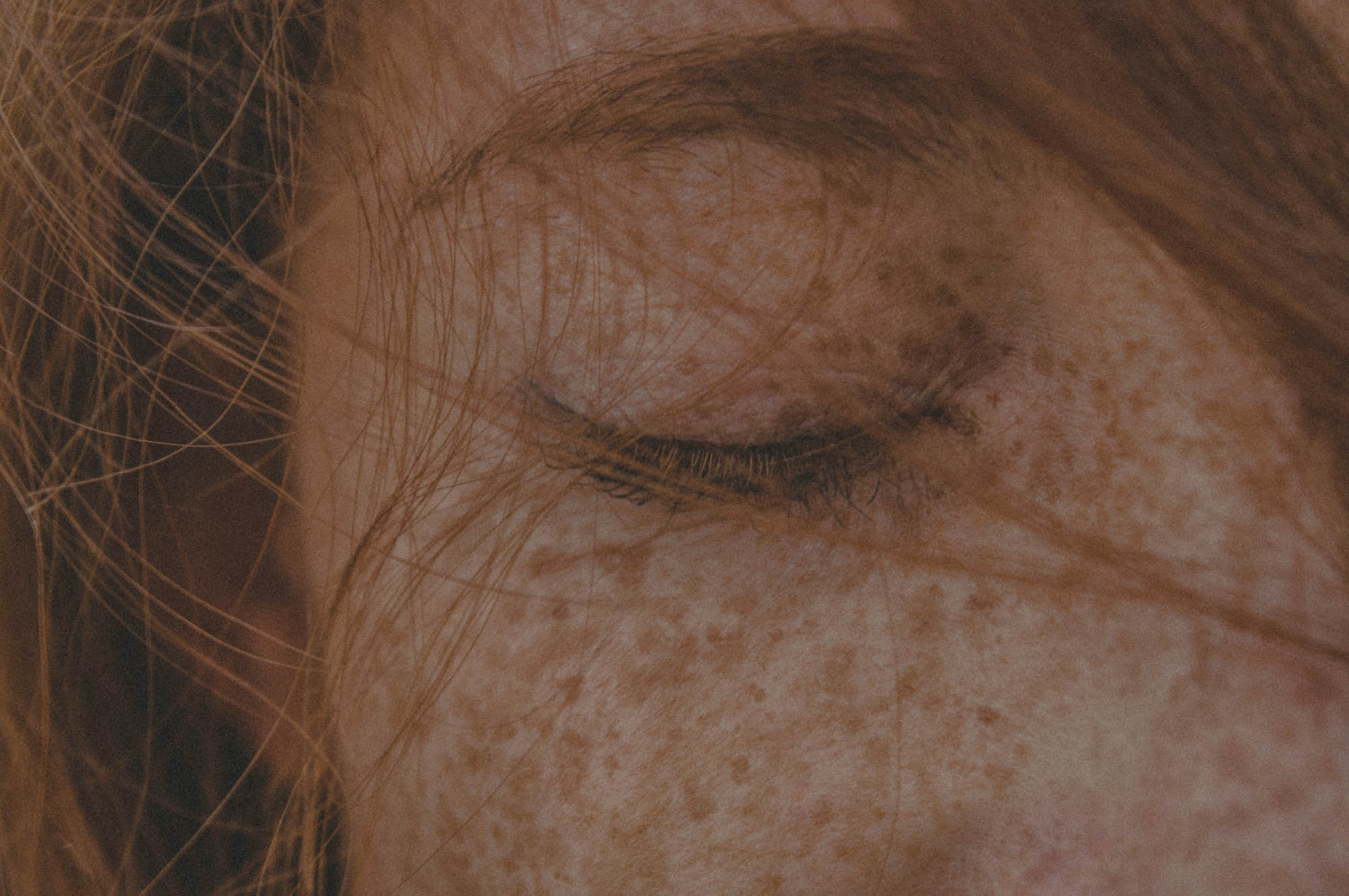 A close-up of a woman's eye that's closed.