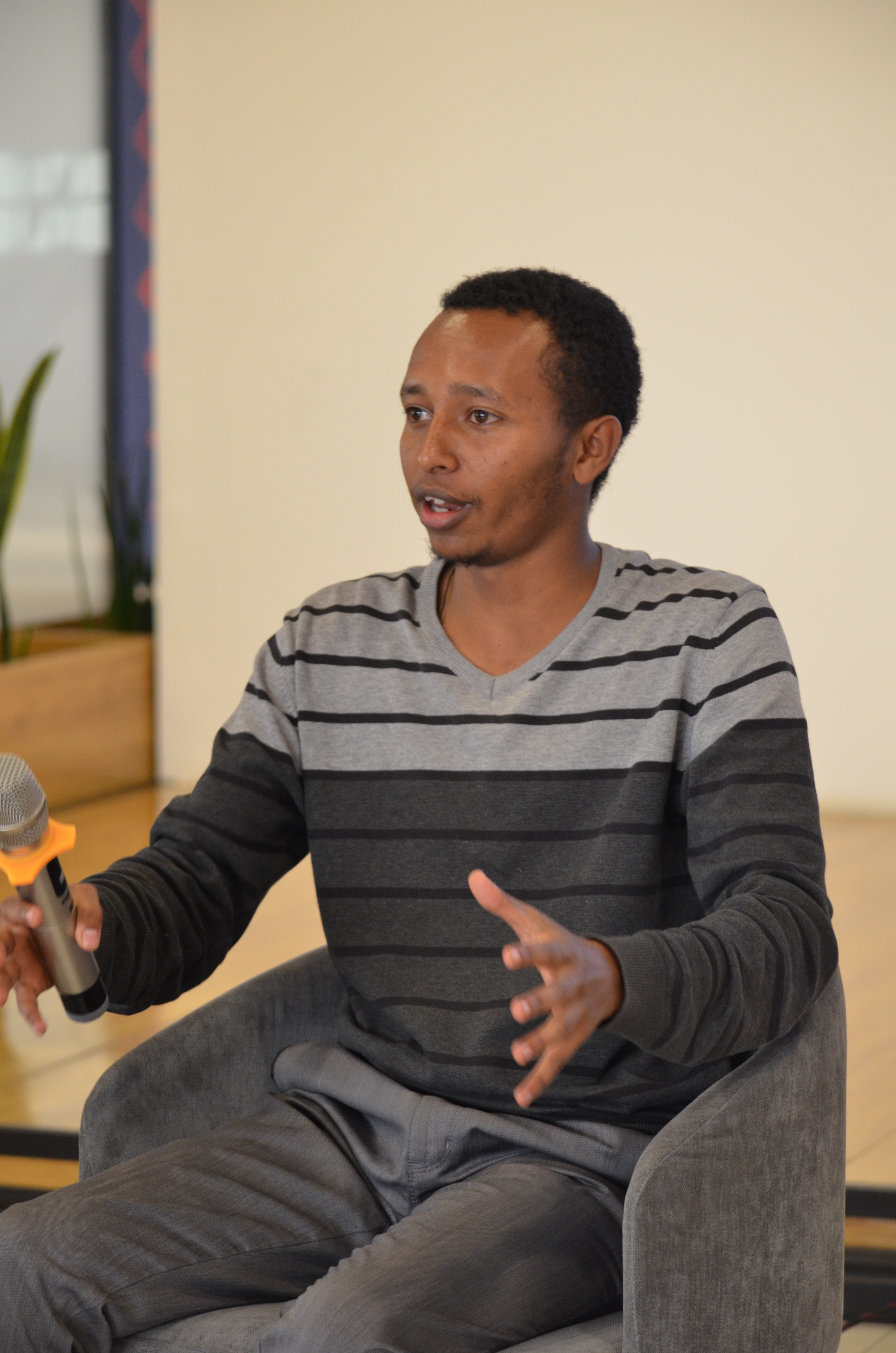 Close-up of a yellow tennis ball sitting on a green court, positioned near the white center line.