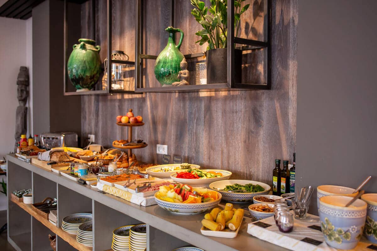 Breakfast table with fresh food, coffee, and juice served in a calm, natural setting