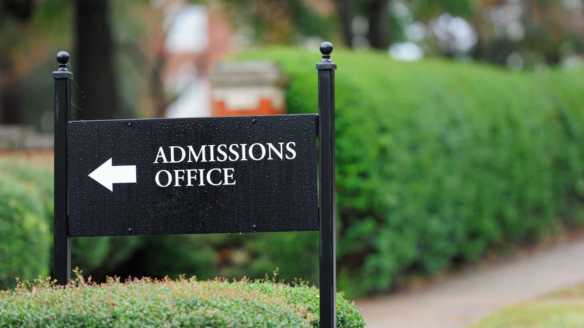 A sign with an arrow pointing the way to the admissions office