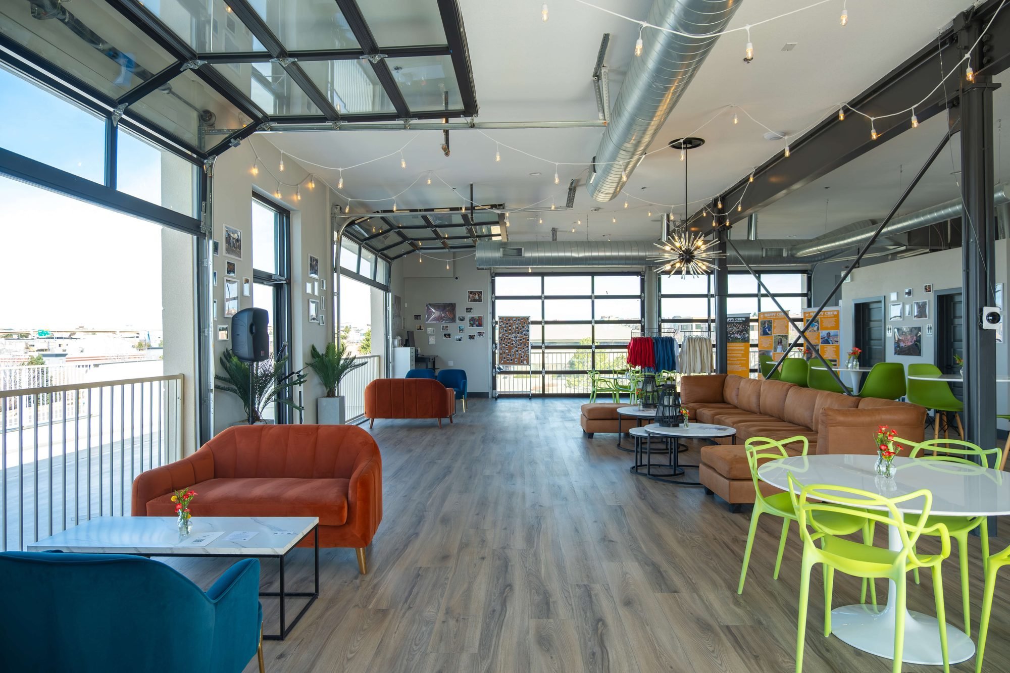 The whole room with the garage doors rolled up, couches and long tables in the light