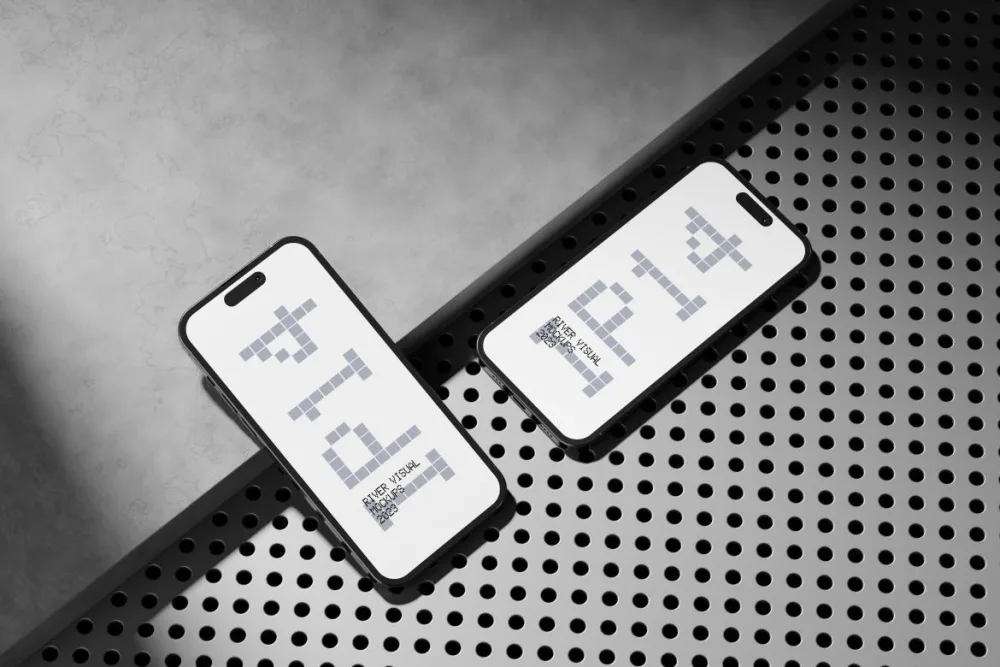 Two modern smartphones placed on a surface combining gray concrete and perforated copper metal. The devices display a clean interface with thin bezels, showcasing sleek, minimalist design elements.