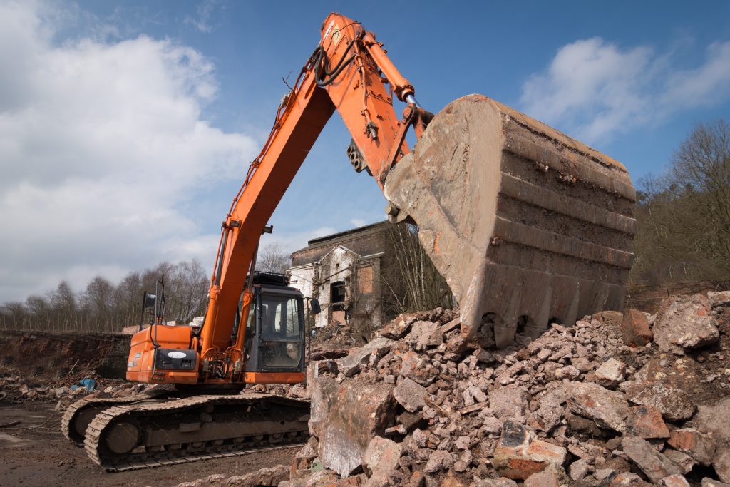 Excavator performing structure demolition and site clearing in Kansas City