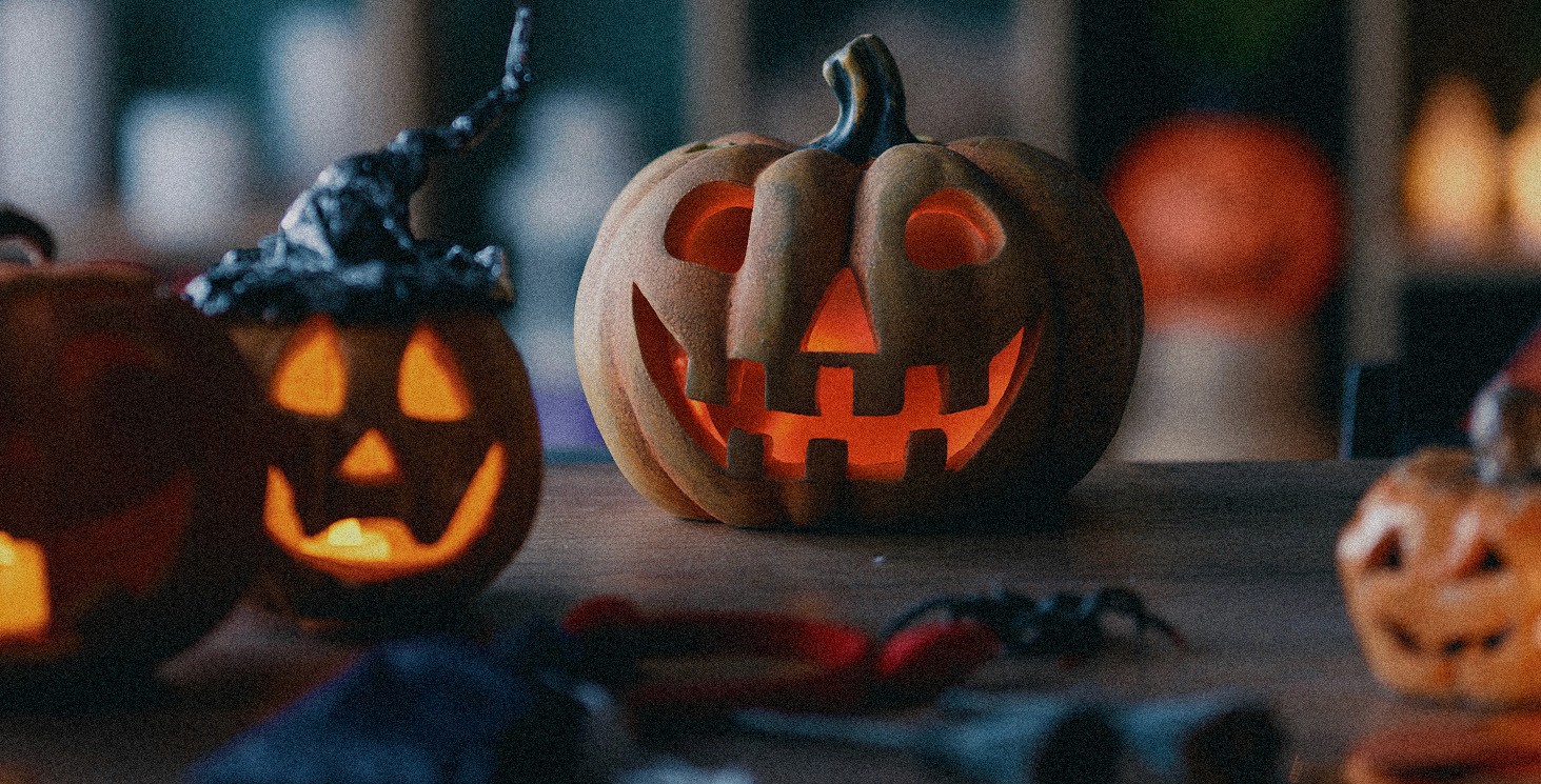 A grainy image of some small and medium sized jack-o-lanterns.