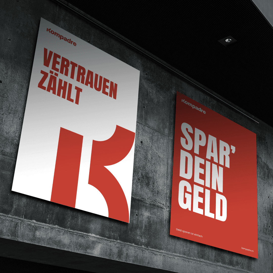 Kompadre poster designs with bold red and white text displayed on a concrete wall.