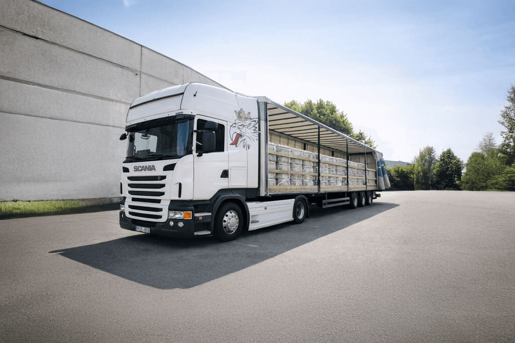 Áruval feltöltött ponyvás nyerges kamion parkol egy felrakodás után